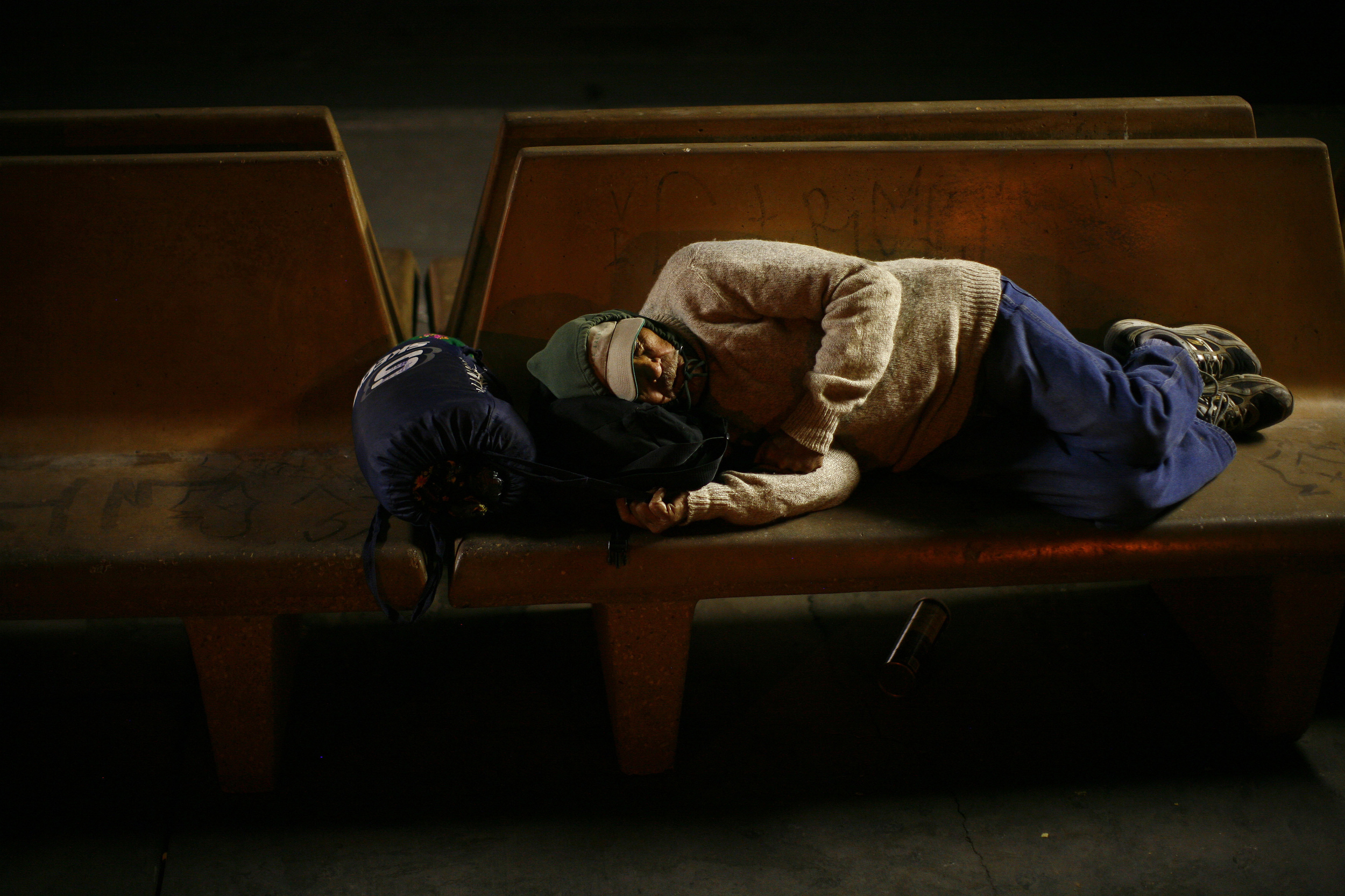   A man sleeps on a bench near the U.S./Mexico border in Calexico, CA. 2010  