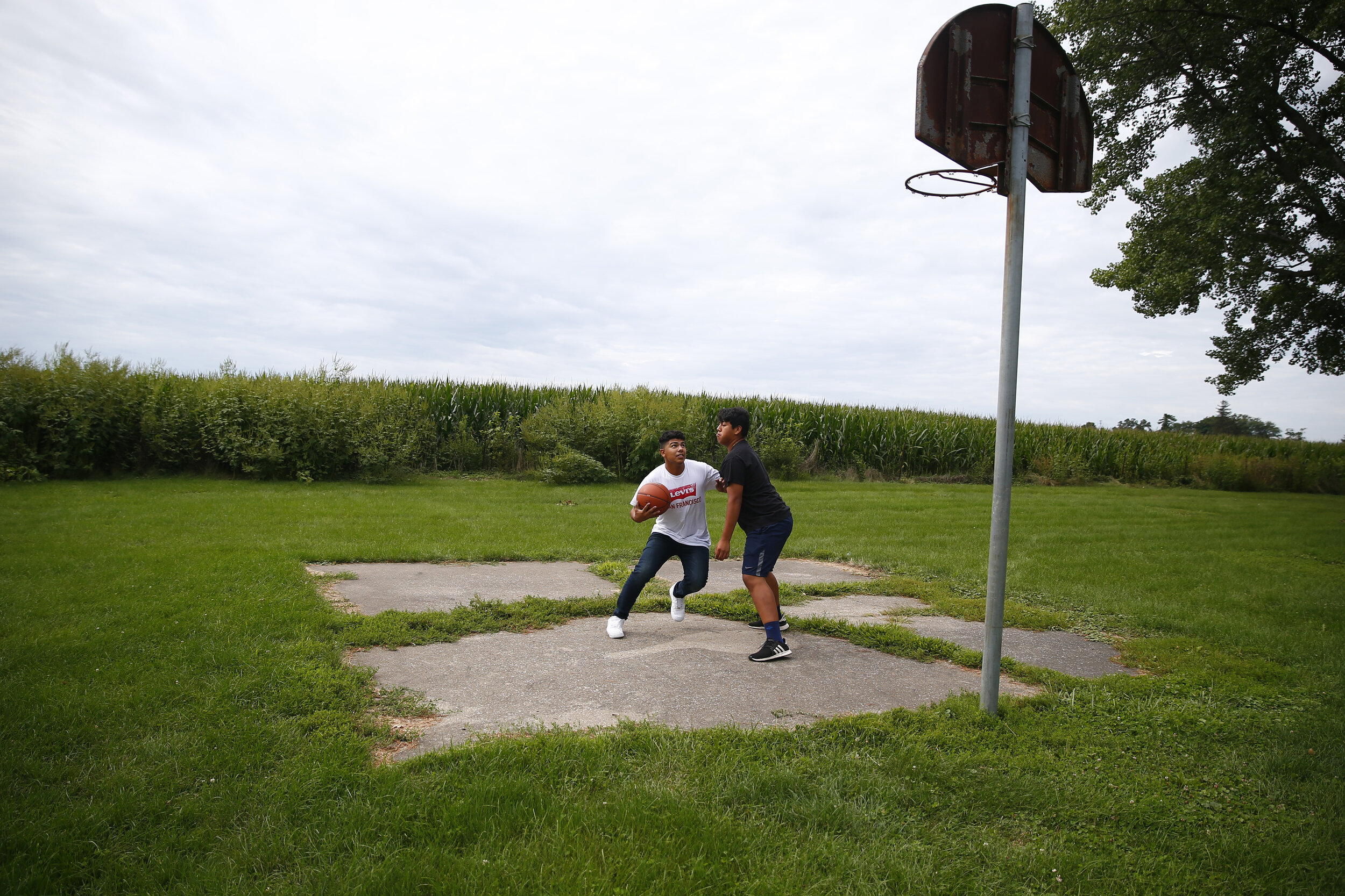   Basketball next to a cornfield in West Liberty, IA. 2019. The town is in Muscatine County, Iowa, and as of the 2010 U.S. Census was the only city in the state to have a majority Hispanic population.  