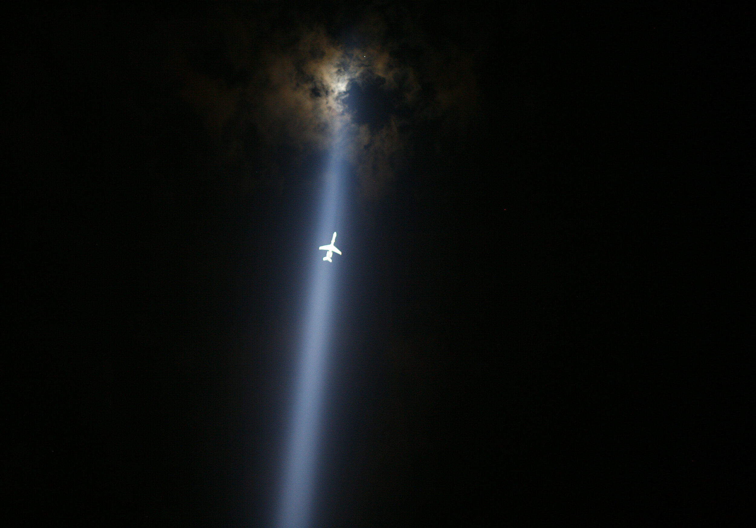   A plane flies through the Tribute in Lights. Ten year anniversary of 9/11. New York, NY. 2011  