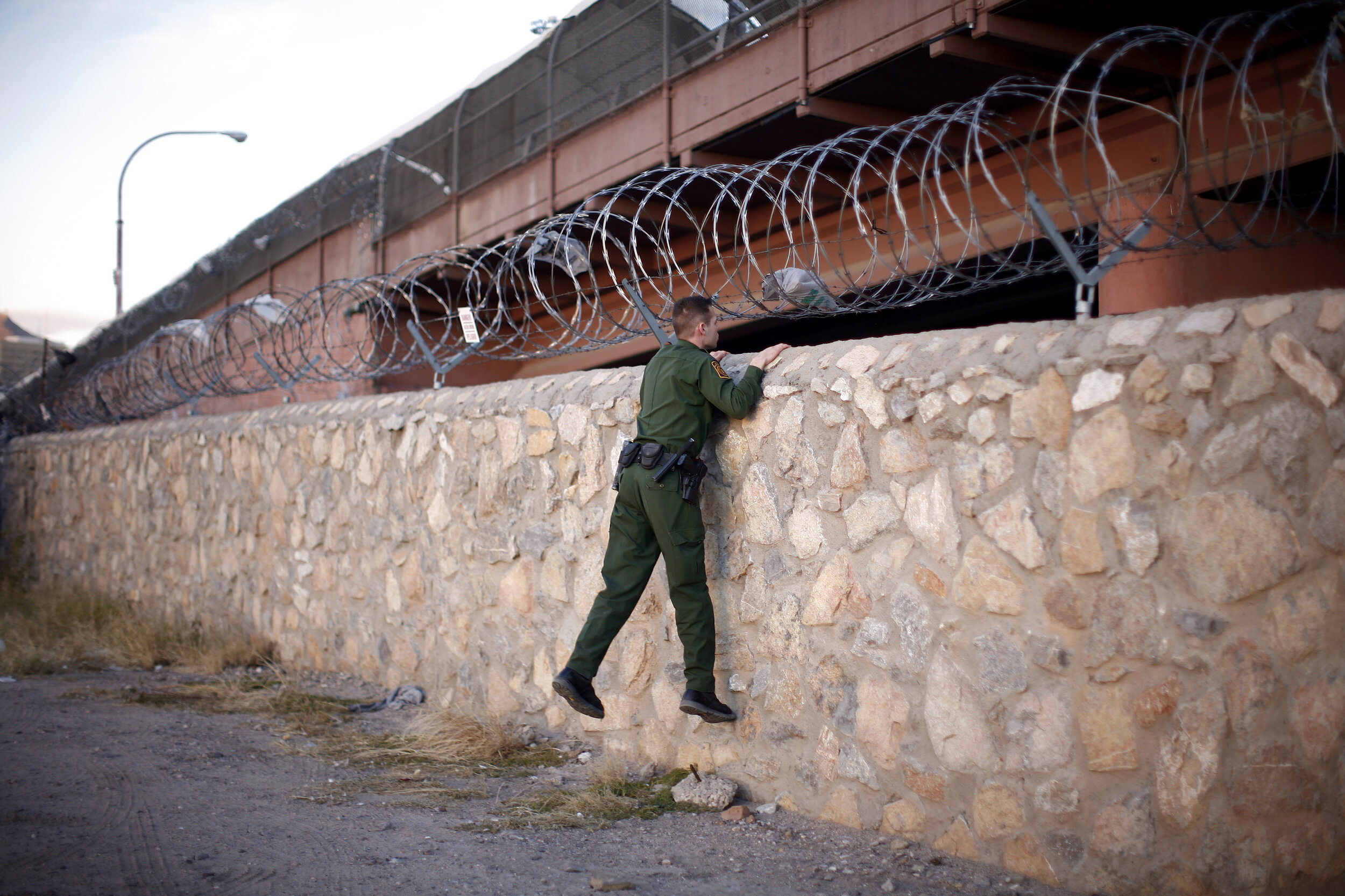   A U.S. Border Patrol agent looks over a wall at the U.S./Mexico border in El Paso, TX. 2010  