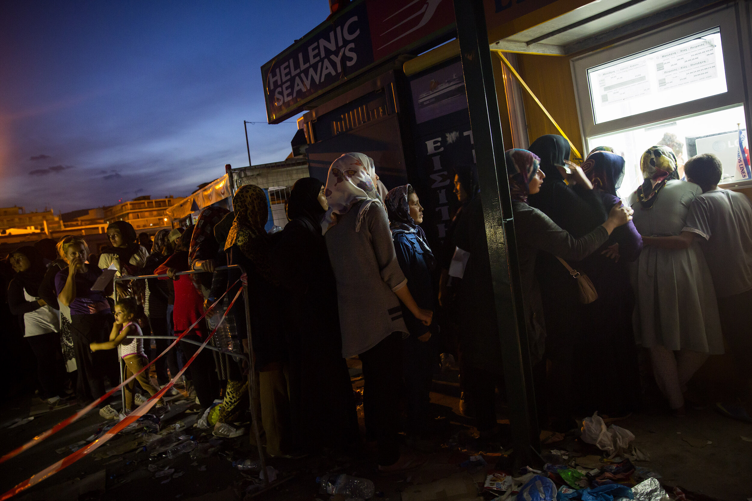   People who had come ashore from Turkey onto the Island of Lesvos, Greece wait in line to buy ferry tickets to Athens during a mass exodus from Syria. 2015  