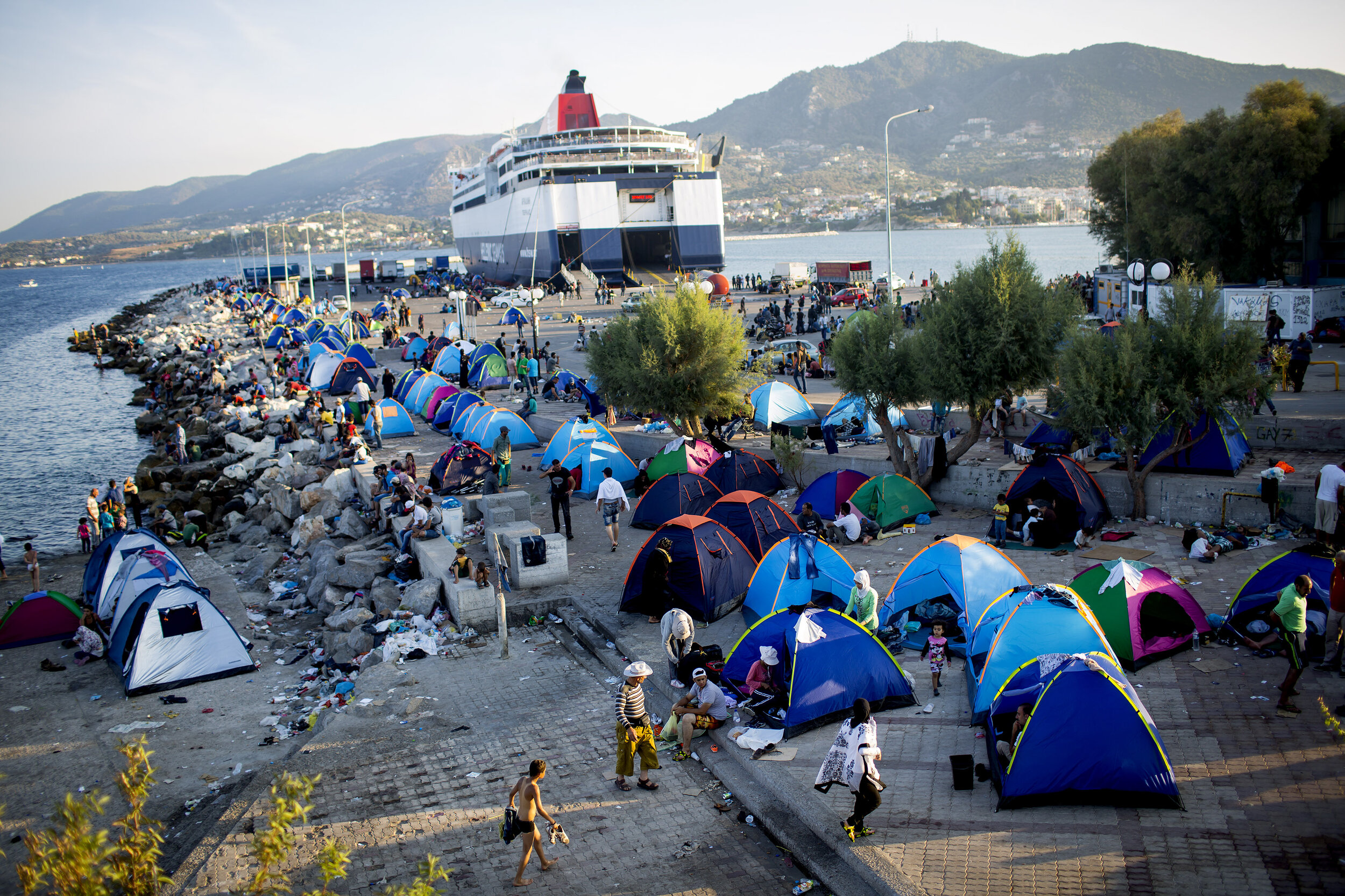   People who had come ashore from Turkey onto the Island of Lesvos, Greece camp as they wait for government permission to travel by ferry to Athens during a mass exodus from Syria. 2015  