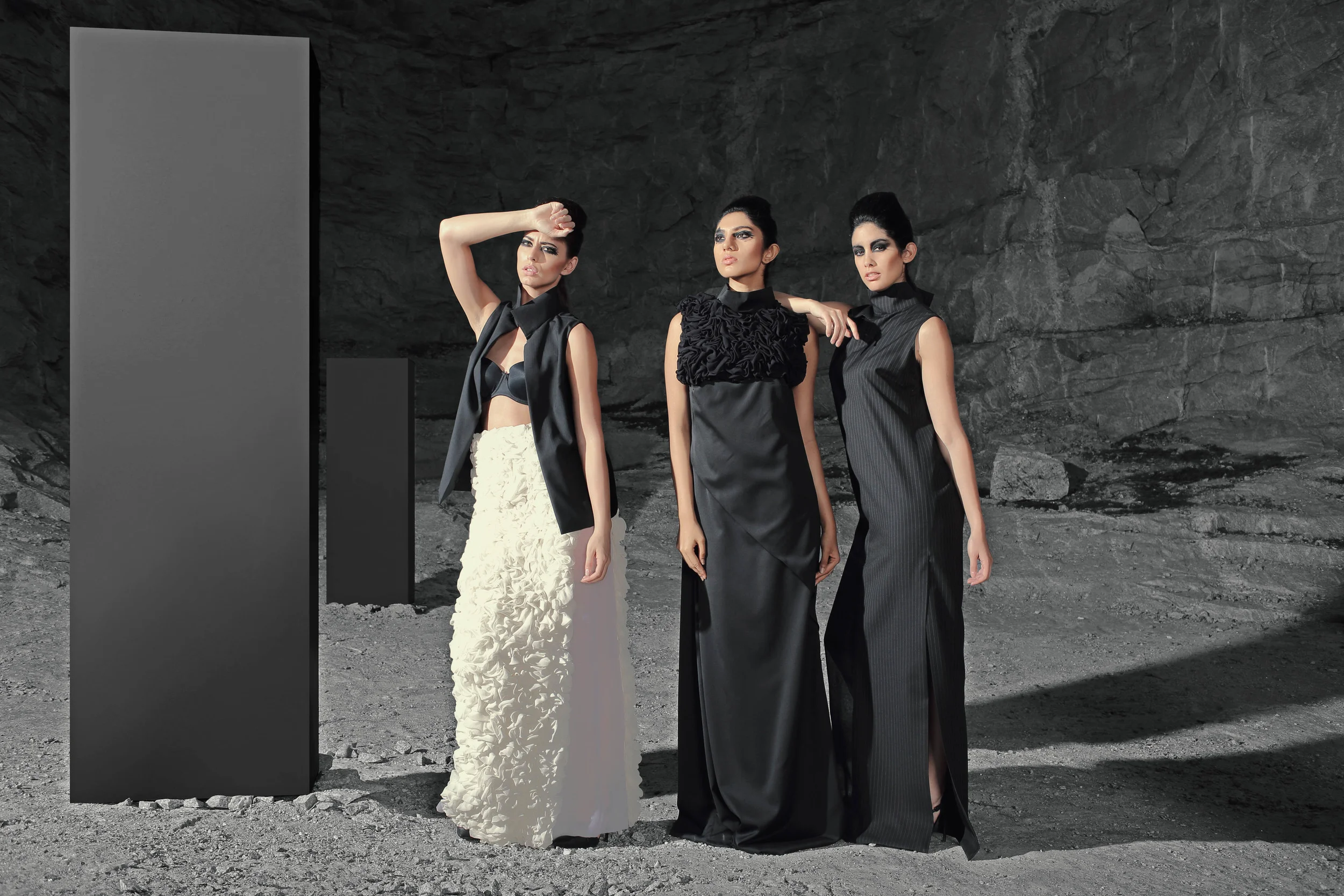On Talesha, Look 1.15.26 Sleeveless Jacket & long skirt with ruffles and organza panels. On Amrita, Look 1.15.28 Long dress with asymmetrical pleats and ruffled detailing. On Maria, Look 1.15.08 Long dress with pleat detailing and asymmetrical organza panel A.Criton