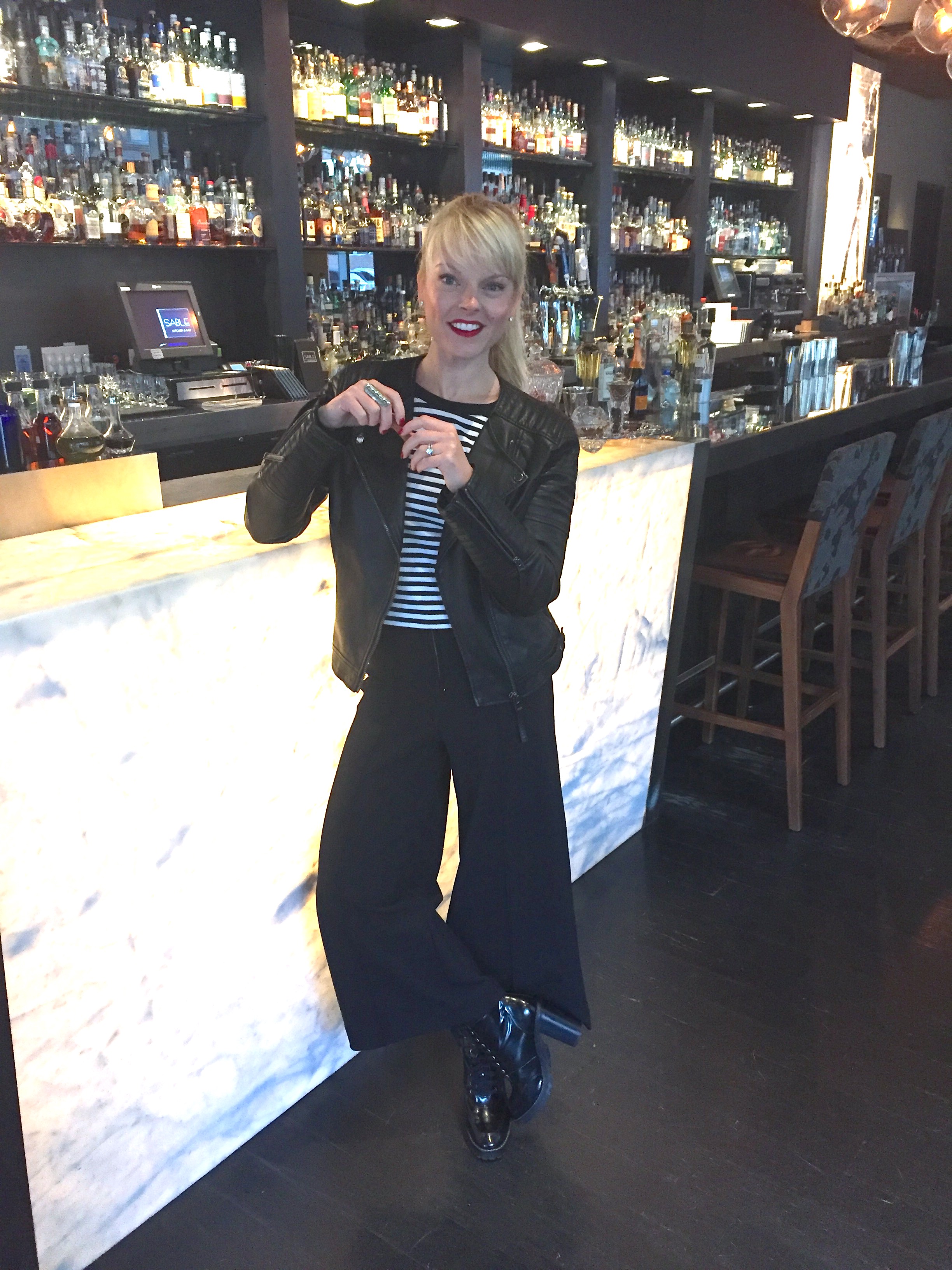 Johanna wearing a striped tee, moto jacket, and wide leg pants