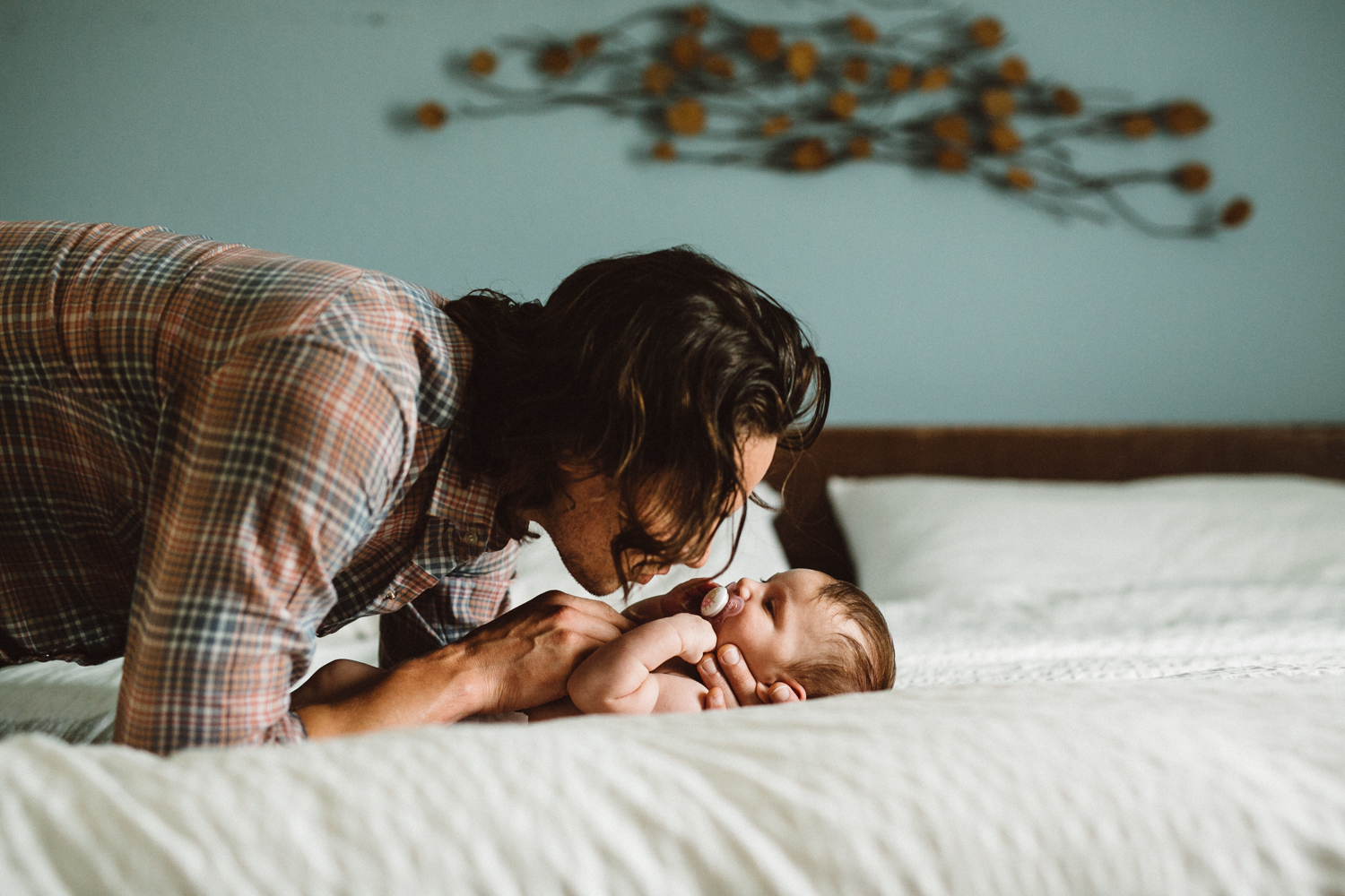 dad kissing newborn daughter