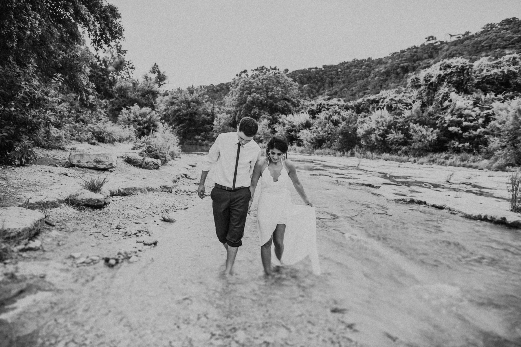 bride and groom walking through water