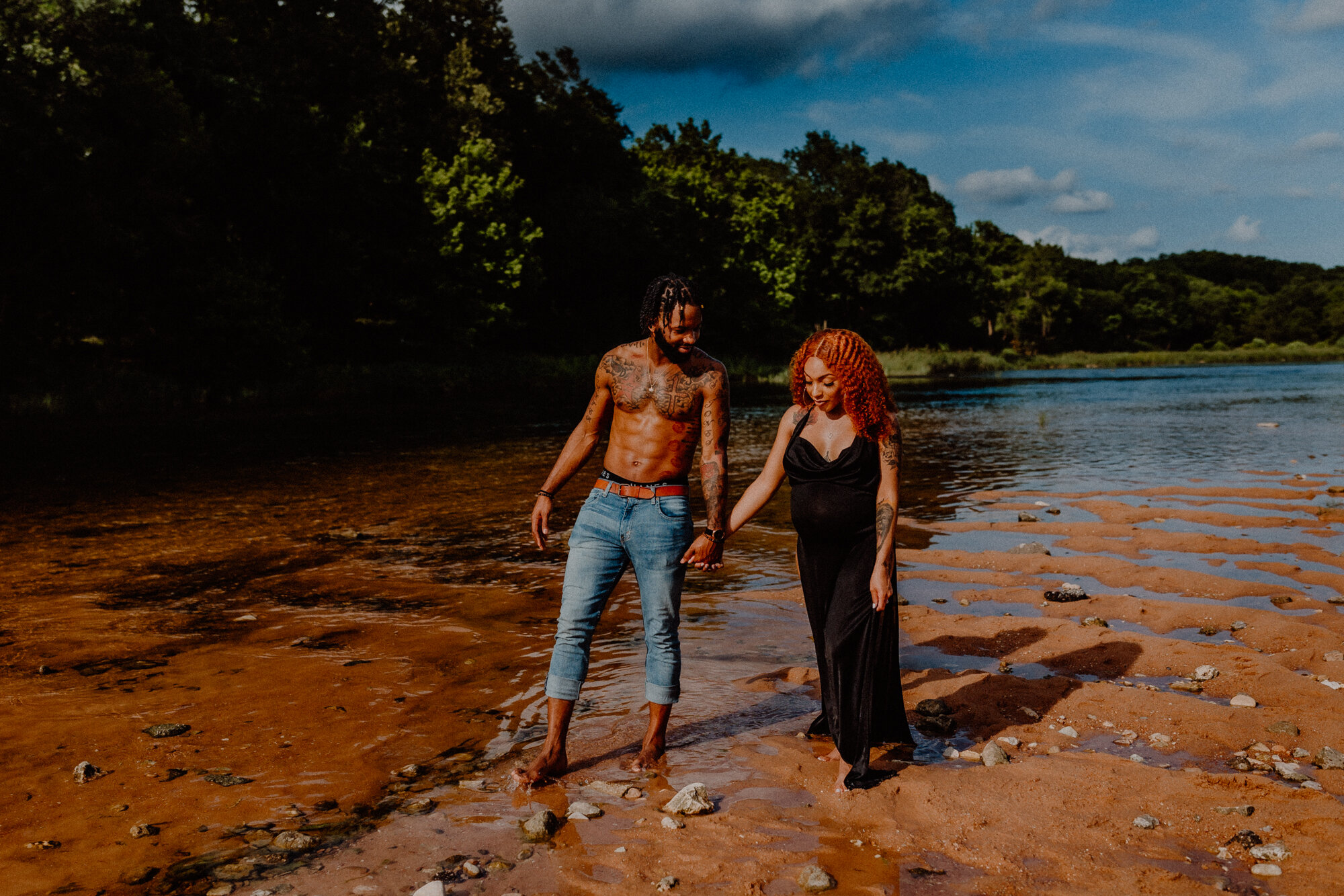 couple walks through the water during photoshoot