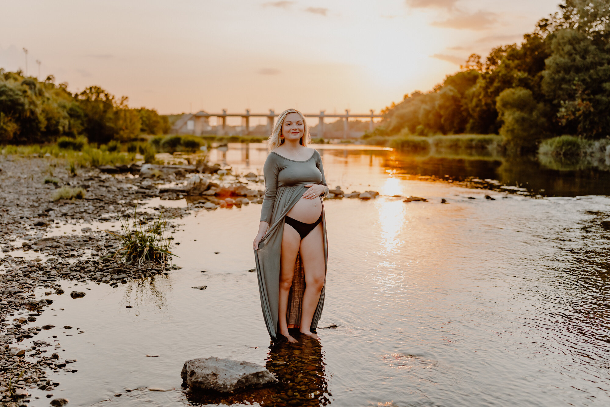 pregnant woman in the river bed with sun flare