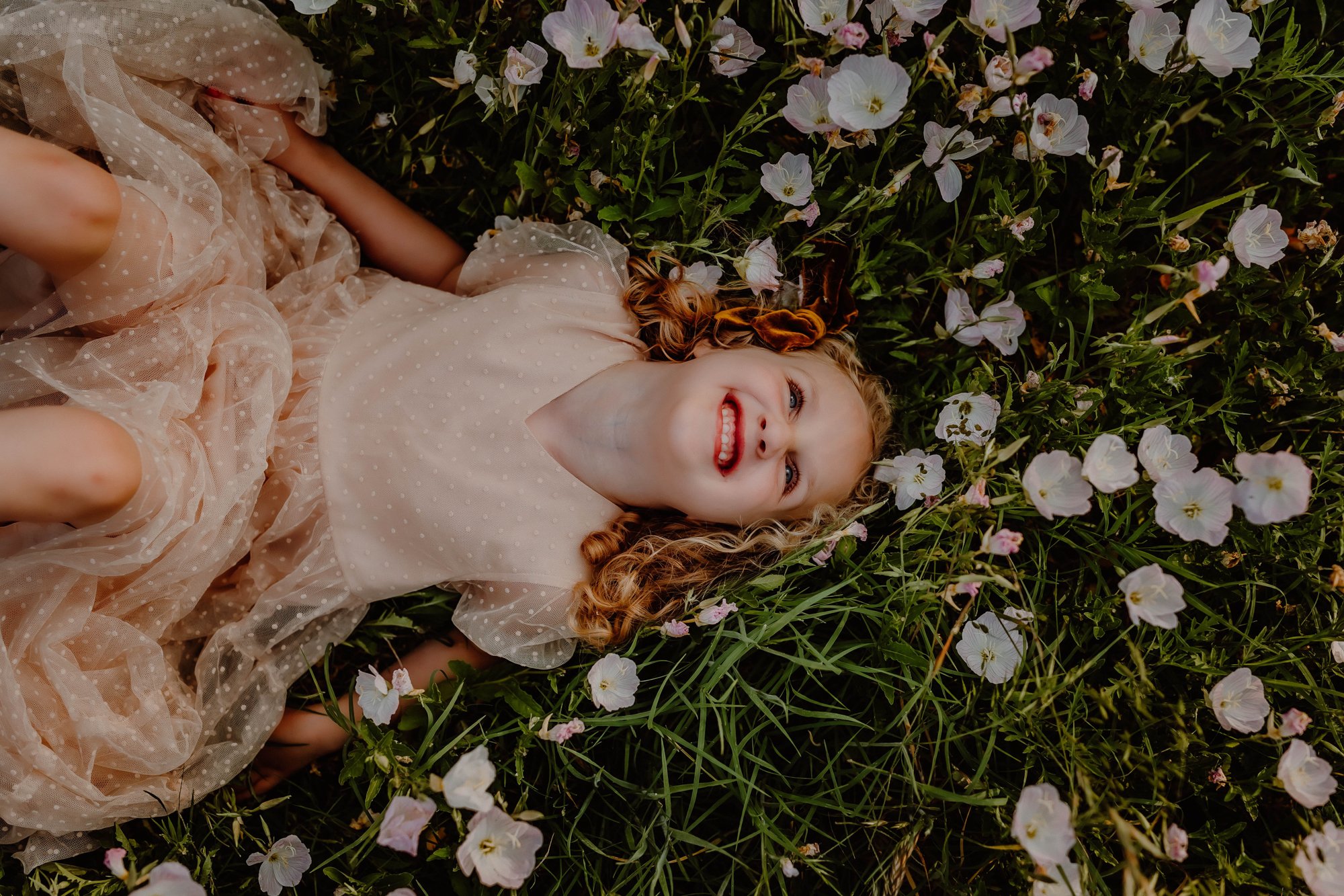 girl lays in field of wildflowers