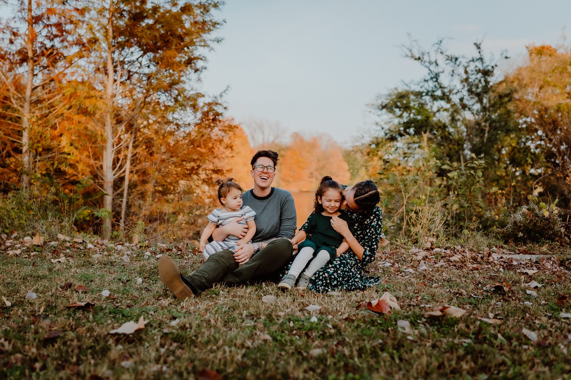 family sitting on grass fall colors