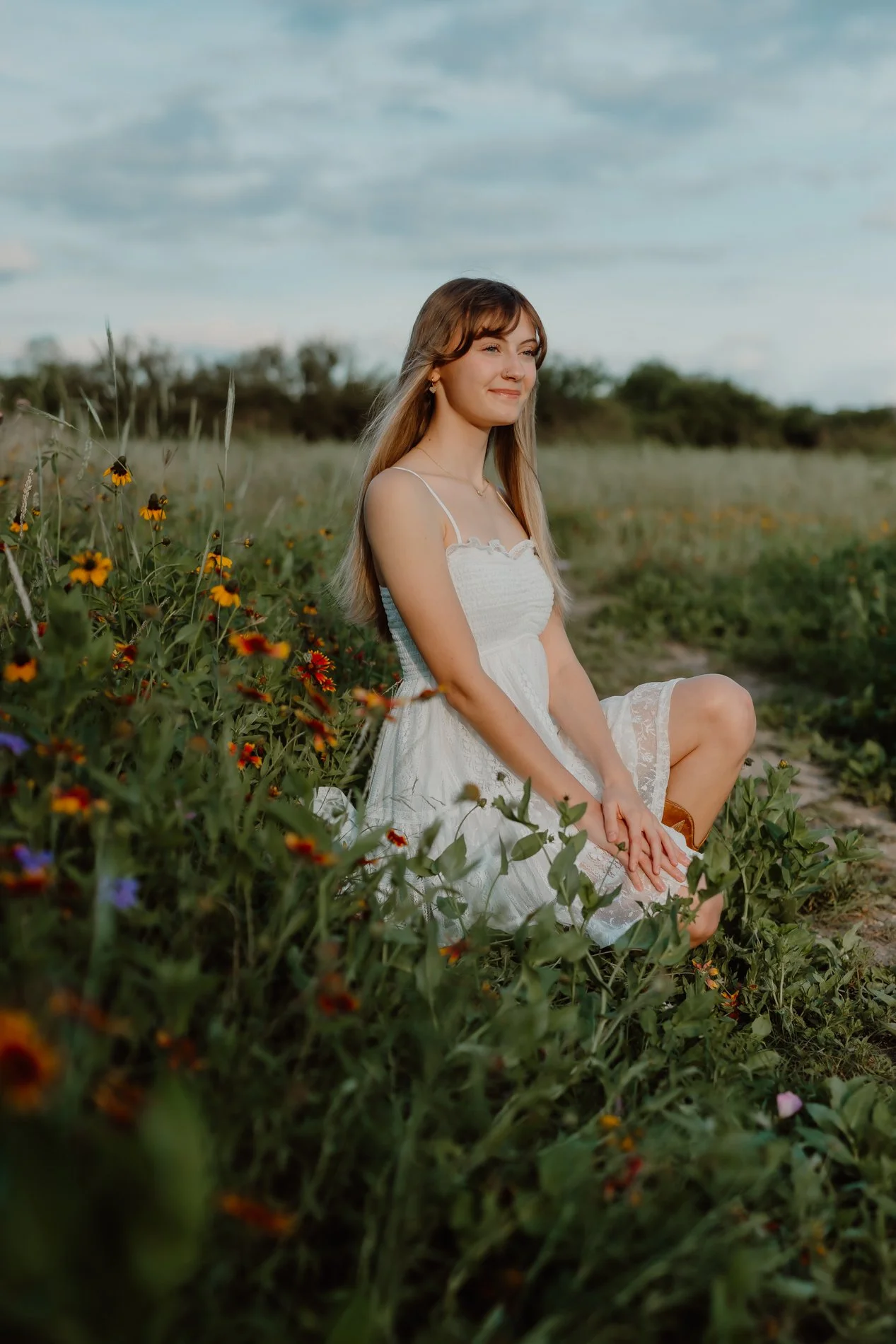 Candid lifestyle senior photo of Dylann twirling in a wildflower meadow during her Austin senior session