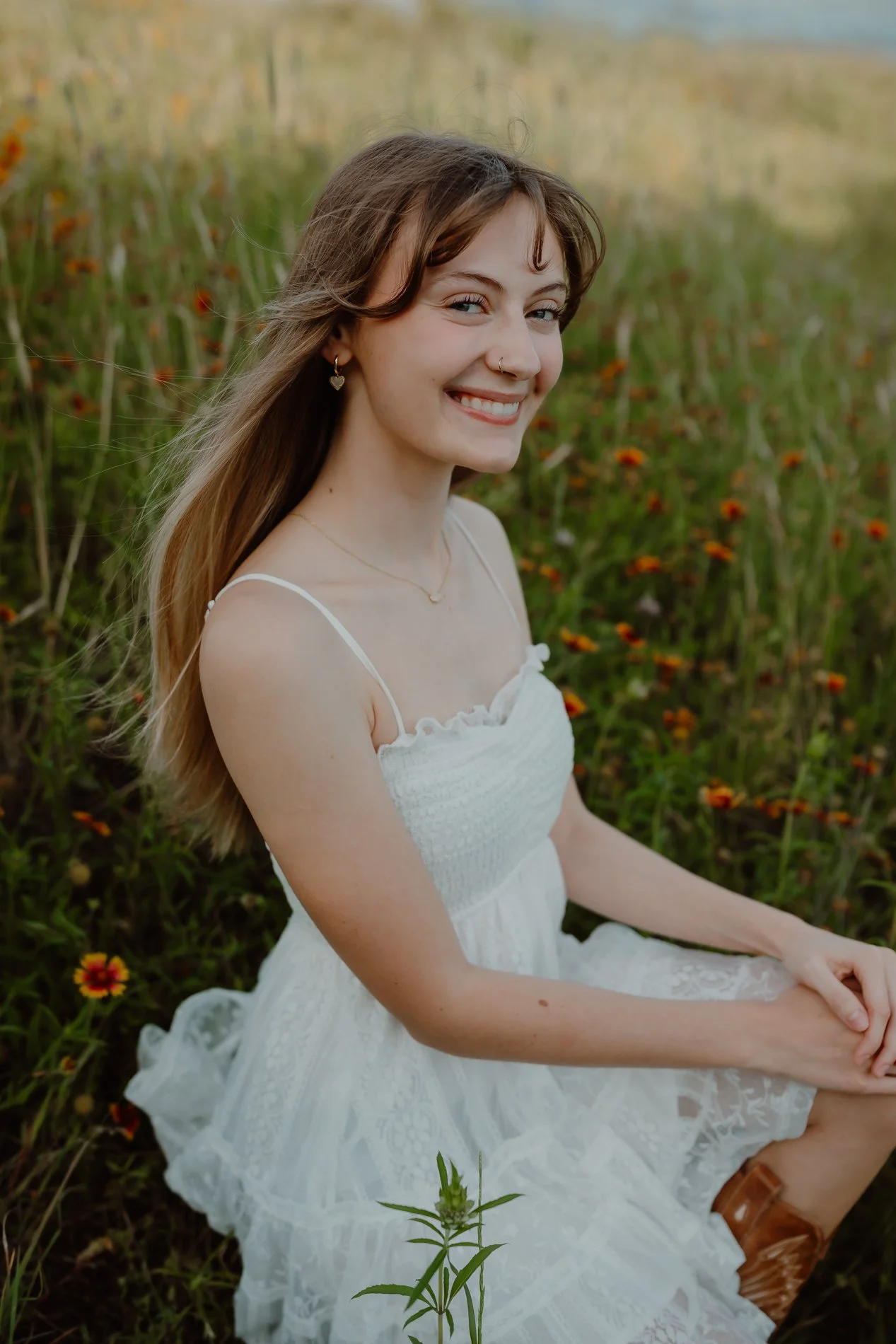 Close-up portrait of Austin senior Dylann holding a bouquet of hand-picked Texas wildflowers.
