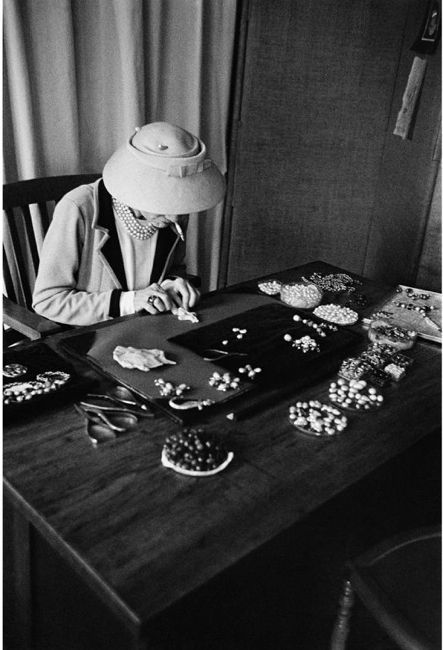 Coco Chanel designing her famous pearl necklaces.