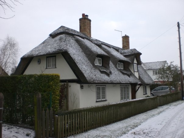 Thatched cottage, in the Fens during the big snow, Cambridgeshire, UK (Feb 2009)