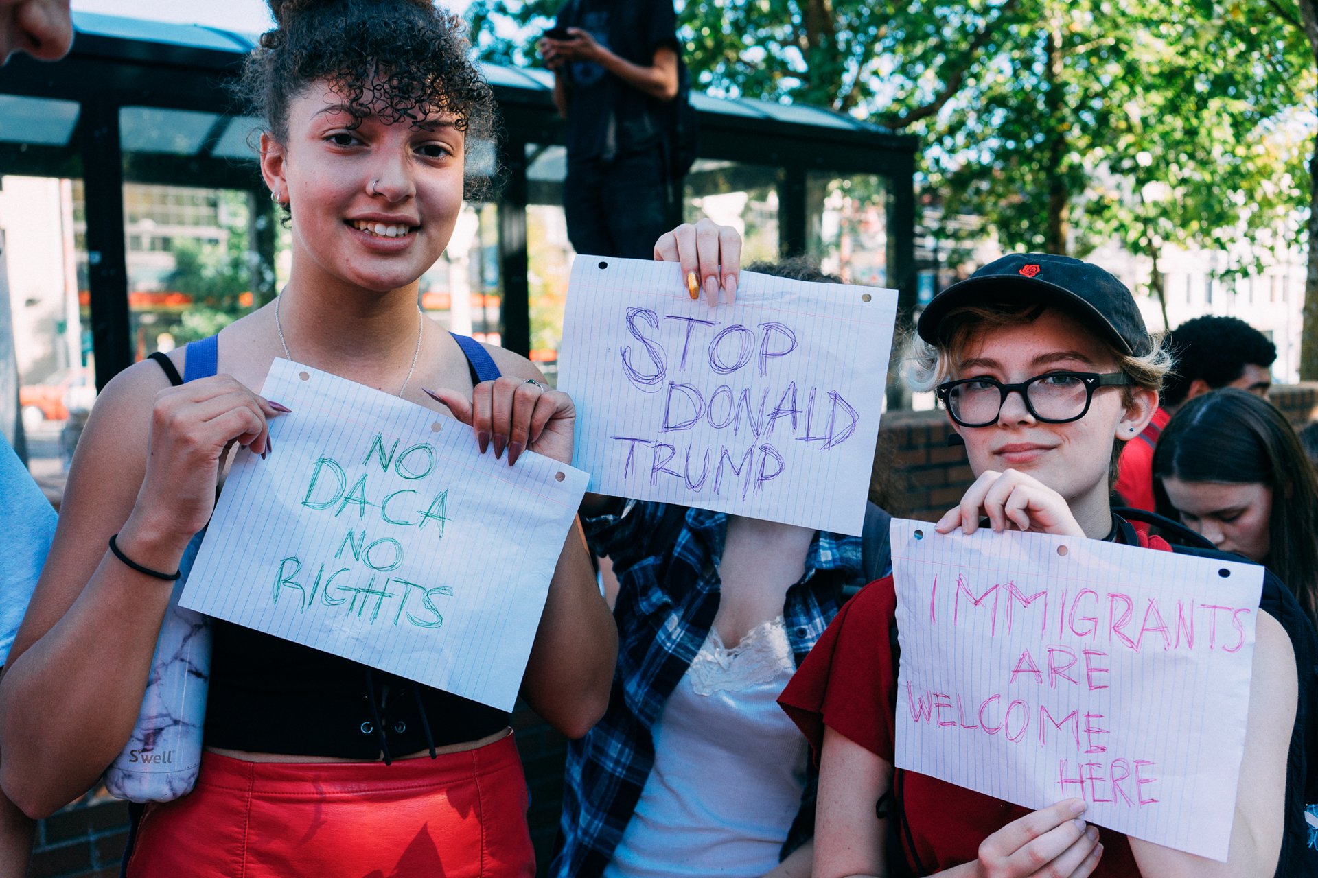  Students pose with signs at a rally supporting DACA recipients. 