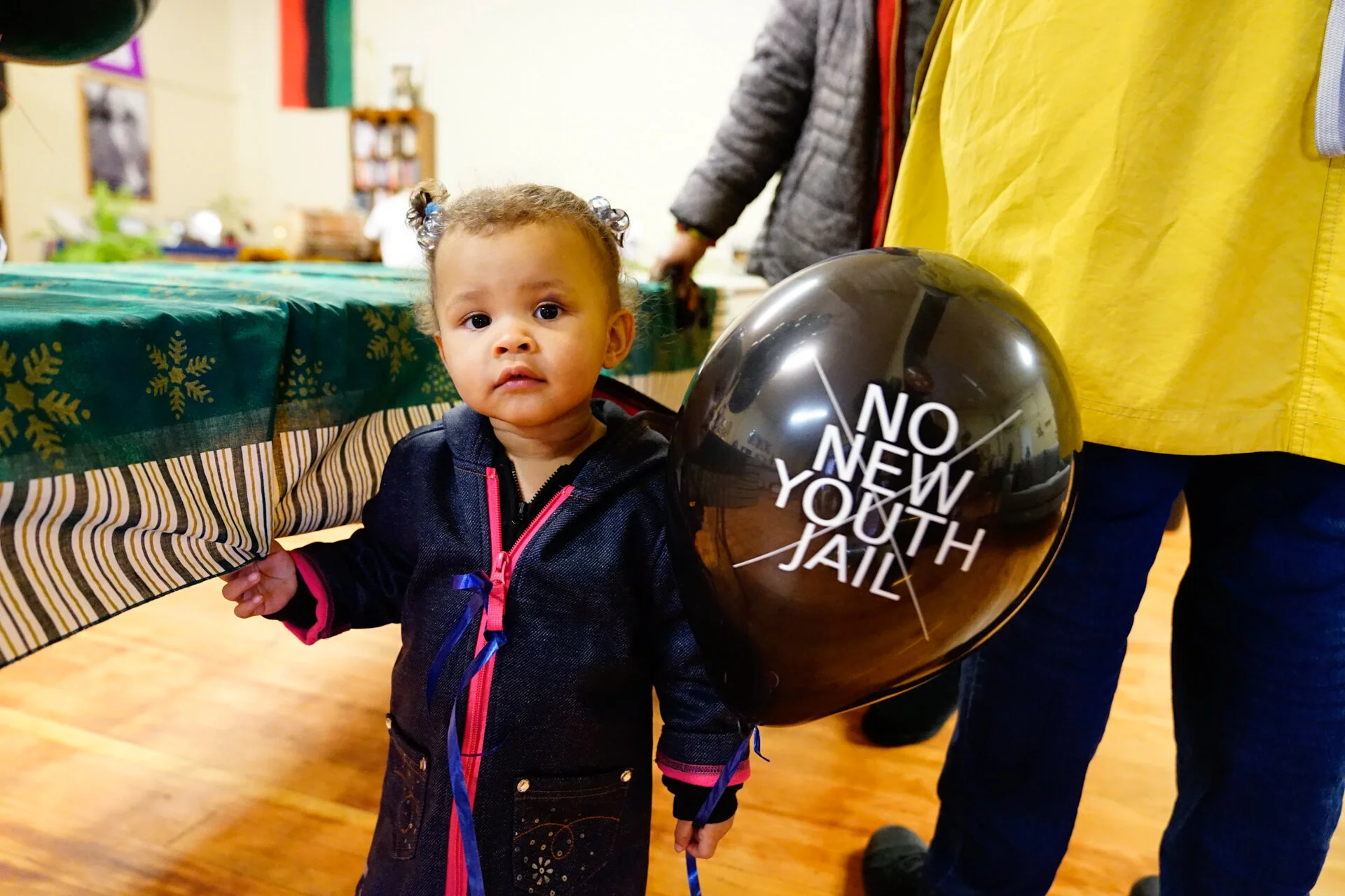 A young girl holds a balloon at a ‘No New Youth Jail’ meeting. The organization has been fighting against the new King Country juvenile detention facility since 2012.