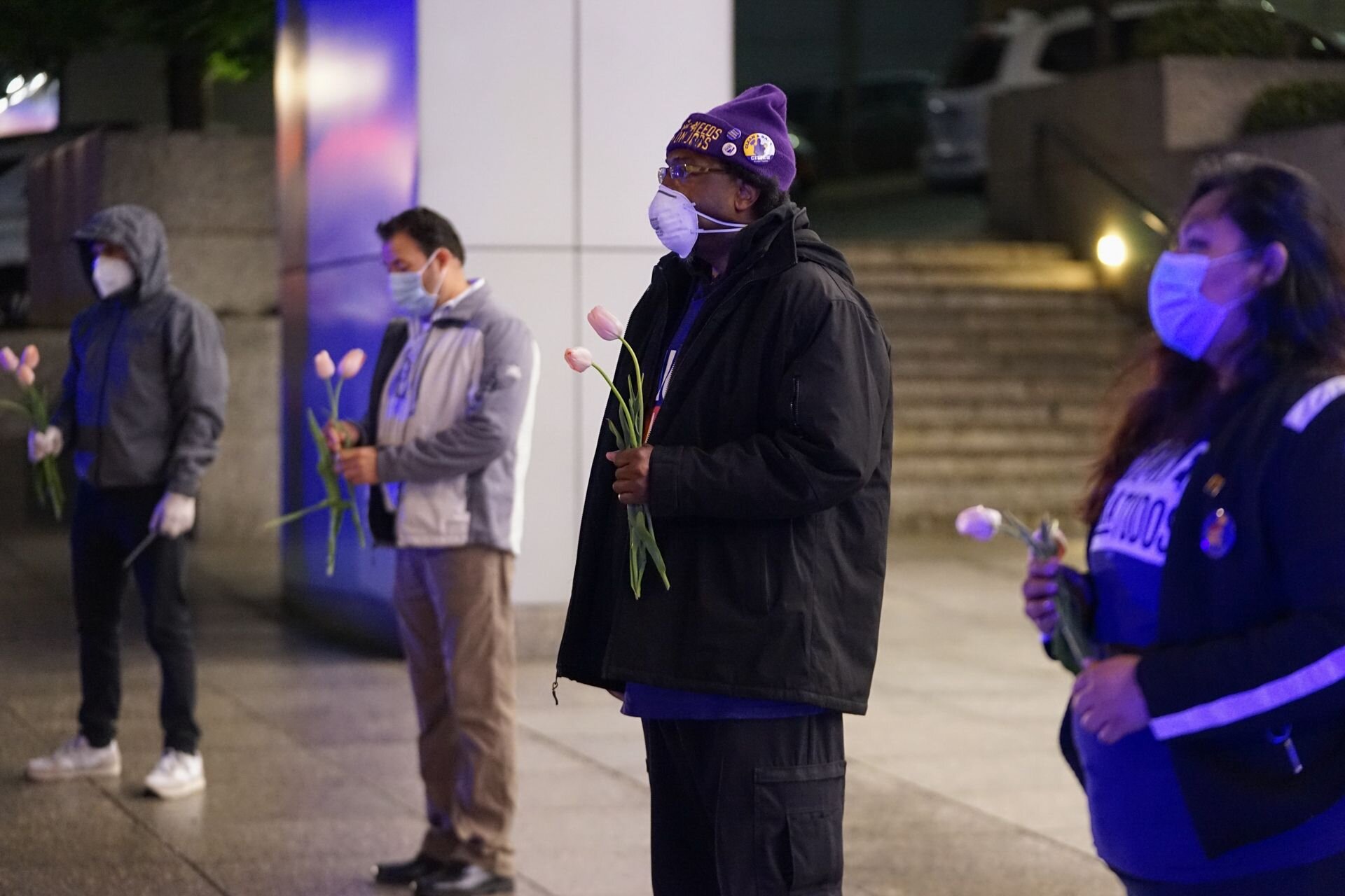  Janitors and security officers hold a moment of silence at a candlelight vigil for their coworkers effected by COVID-19. There are glaring disparities in the rates of infection among black and latinx people, who make up a large percent of this essen