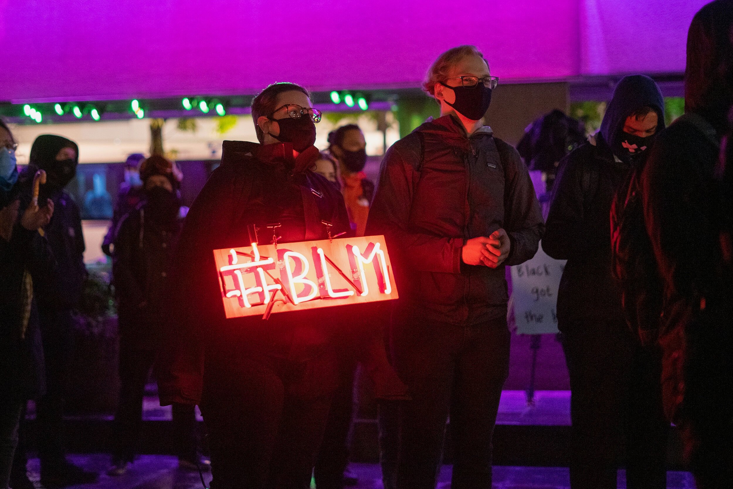  Alleson Buchanan holds a homemade neon sign in a crowd of protesters in Seattle’s Westlake Park. Dozens gather to protest the lack of consequences for Breonna Taylor’s killers on September 23, 2020 for New York Times.  