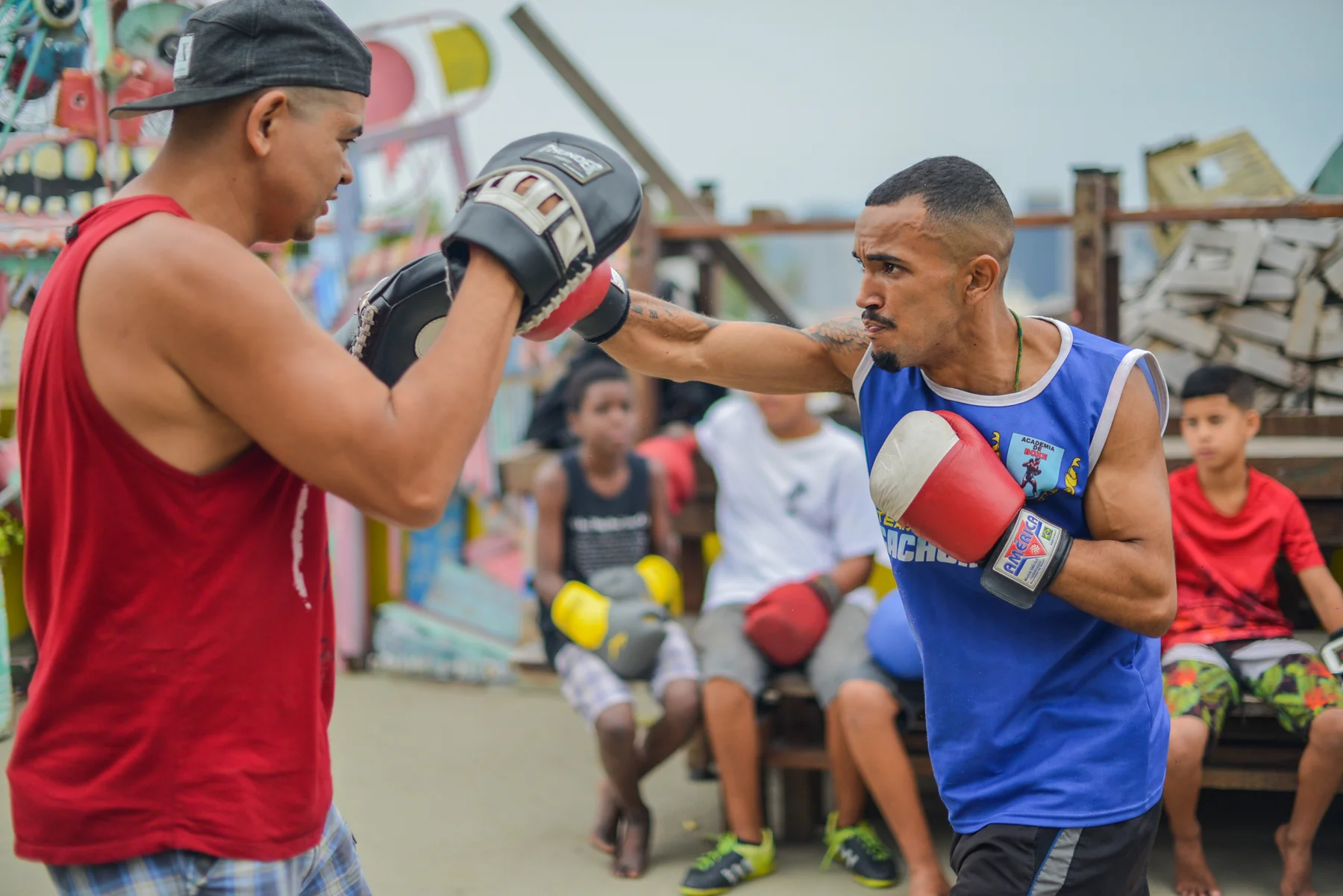 Erivan Feitosa - Boxe Tenho 24 anos. Nascido e criado no Morro da Providência, sou professor e atleta de boxe, atualmente dando aula para cerca de 100 crianças. O que mais me motivou a dar aula na Casa Amarela foi que me enxergo no meio dessas crianças. Eu também fui um deles, cresci vendo e enfrentando os mesmos problemas que eles. No meio da violência, drogas e preconceitos, consegui enxergar outra saída através do esporte e é isso que eu quero mostrar para essas crianças da Casa Amarela, que nós do Morro temos outros caminhos a serem trilhados, que vão muito além dos becos e ruas da comunidade.