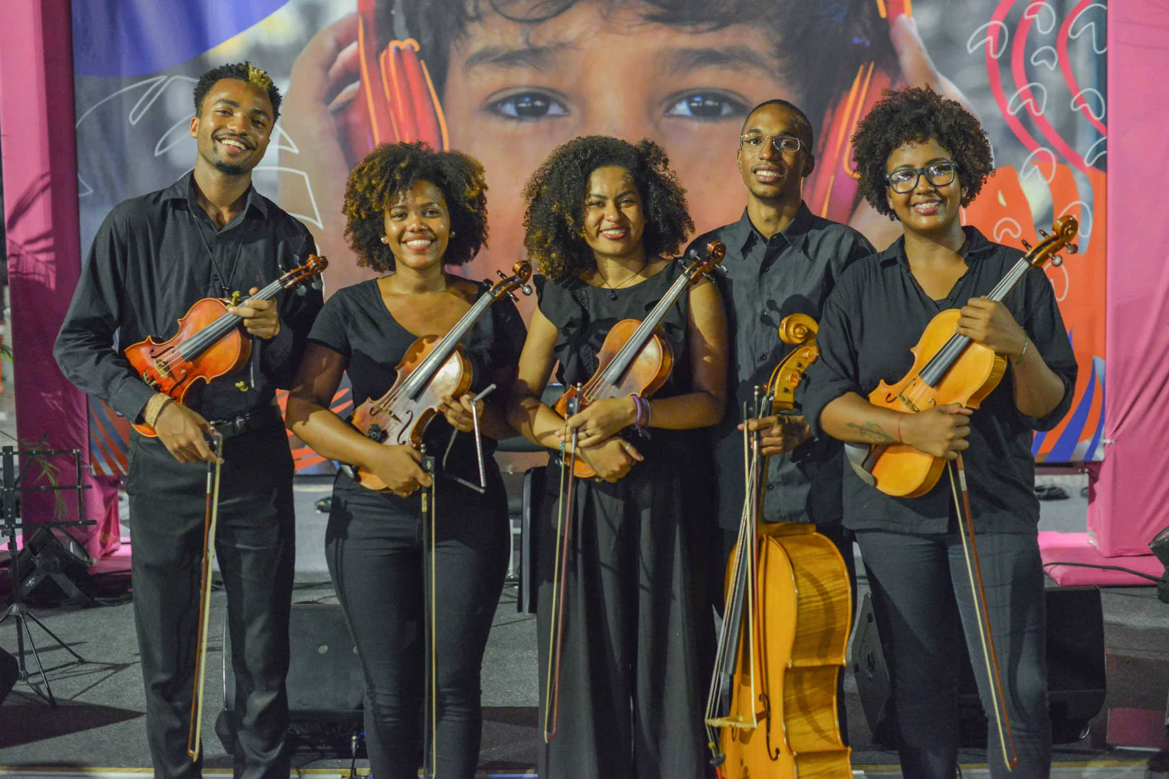 Orquestra de Rua - Gilbert, Juliane, Glaucia, Lucas and Jessica Somos a Orquestra de Rua, grupo formado por cinco jovens moradores de favelas da cidade do Rio de Janeiro. Atualmente cinco de nossos integrantes estão regulamente matriculados nos cursos de música em universidades públicas – UFRJ e UNIRIO - Nosso objetivo é tocar pela democratização da música erudita haja vista que geralmente os moradores de favelas não têm acesso ao repertório e aos instrumentos clássicos. O Grupo procura resgatar a tradição musical das periferias sob um enfoque inovador. Assim, o tradicional dialoga, de forma harmônica, com o clássico e o popular a partir de arranjos coerentes e atuais.