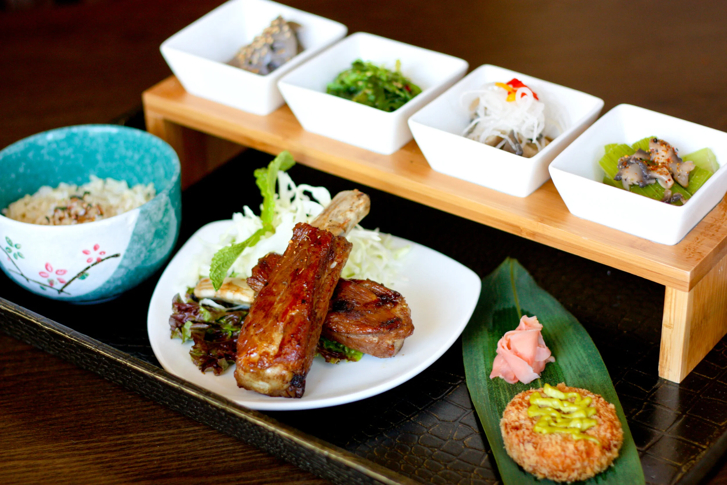 Small plated appetizer set served on a wooden presentation stand.