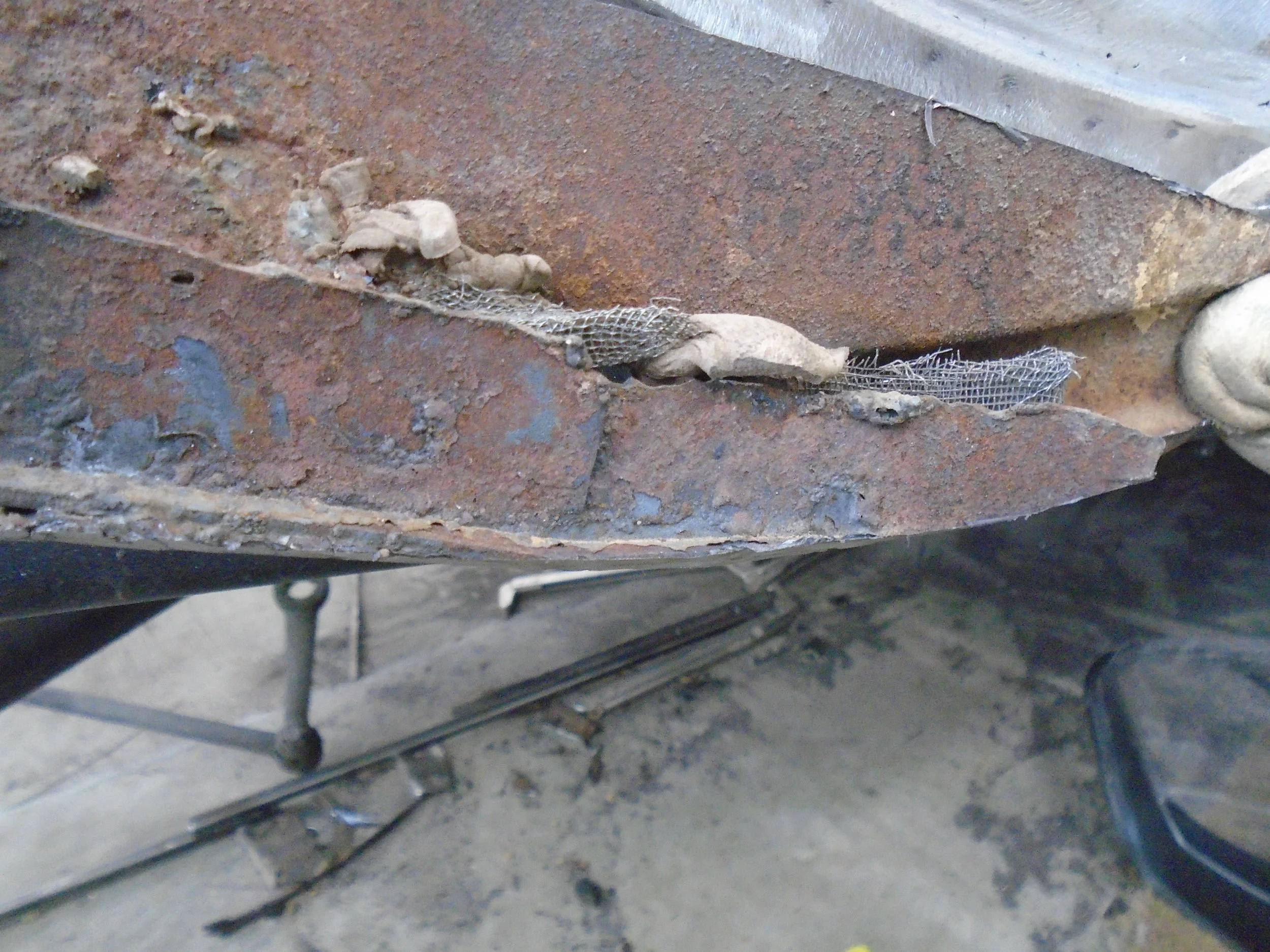  On this close-up you can see someone actually used screen door screen to "fix" this panel 