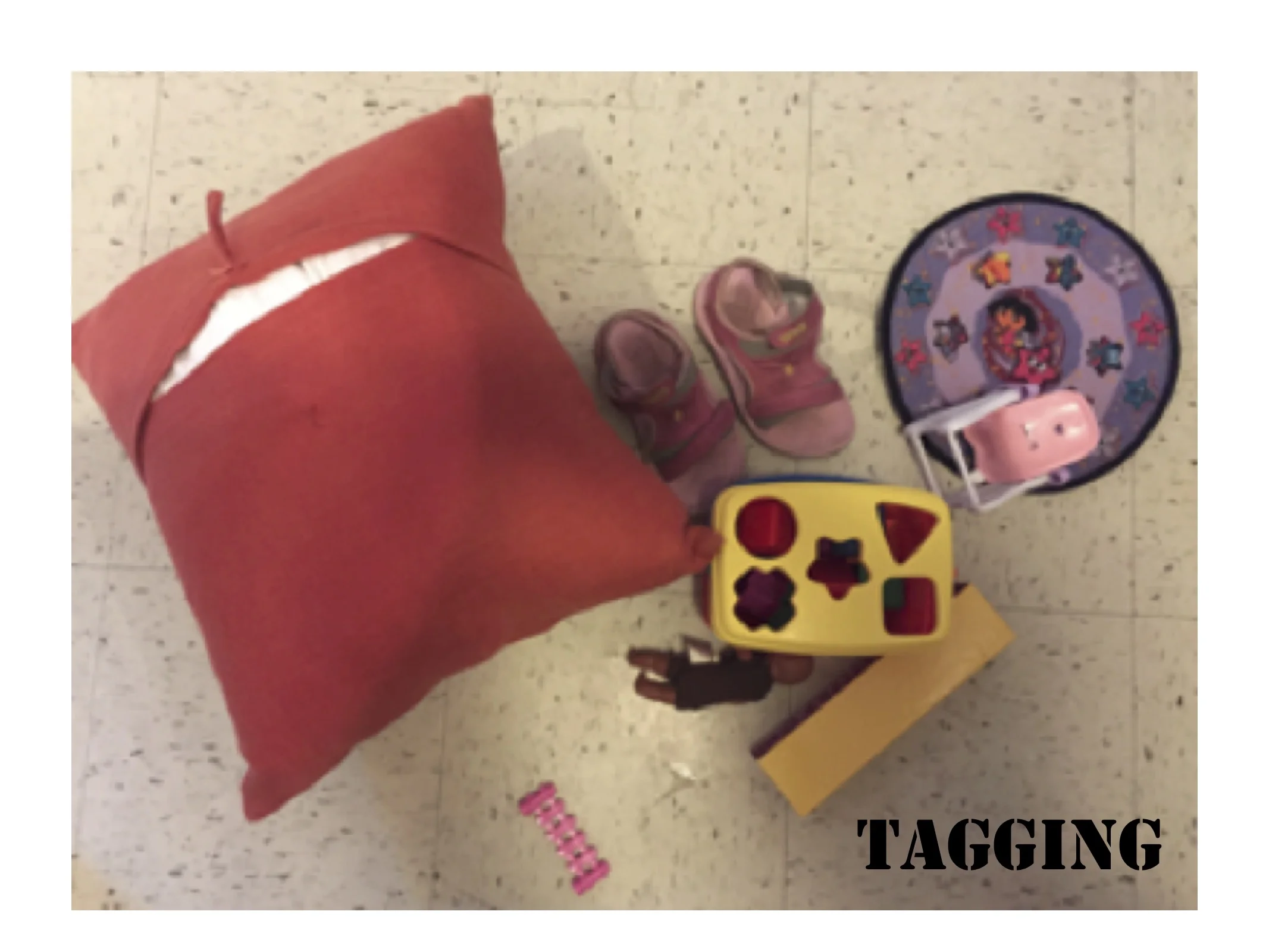 We now relate the actions of the children and the arrangements of materials they leave behind as a kind of “tagging” akin to the graffiti writer. Reframing children’s acts as artistic expression allows us to see beyond classroom practice inscribed by developmental psychology that narrows our teacher gaze to look for a child’s representation of thinking and how they are progressing through developmental stages. These arrangements / tableaux that children assemble have no perceptible traces of a narrative, but they are indicators that some kind of thought, or perhaps sensation, has ‘occurred’ Or what if a narrative is not easily told through traditional modes of telling, such as the genre-blending (Mitchell & Reid-Walsh, 2002, p. 91) scene (above), which includes a pair of reversed shoes, a Dora sun visor, a plastic chair, a sorter, a long plastic block, a tiny baby doll, a small pink fence, and a couch pillow turned so as to expose its less flattering side. The children’s tableaux manage to escape any ability on our part for categorization. They escape the typical boundaries that dictate children’s free play and construction. They happen when we are least aware. We may see the child wandering the room for minutes, seemingly without direction or motivation. However, her eyes scan and analyze the scene.