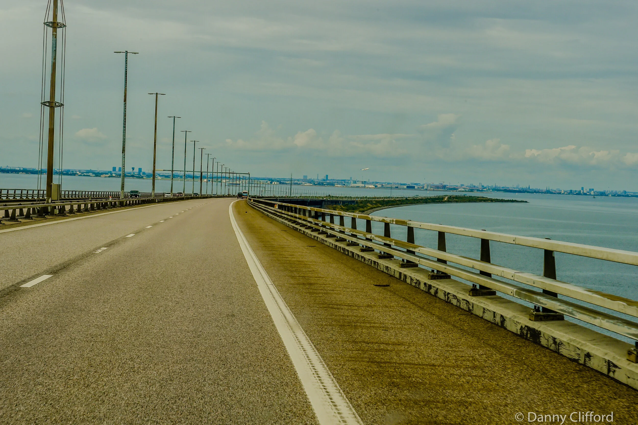 When you are almost over the bridge and heading into Denmark the bridge and the road go down into the water. Yes, look carefully, it does dissapear. You actually go across the wide water expanse on the bridge and then the road goes straight down under the sea and into a tunnel that comes out in Denmark. Well Copenhagen to be precise.