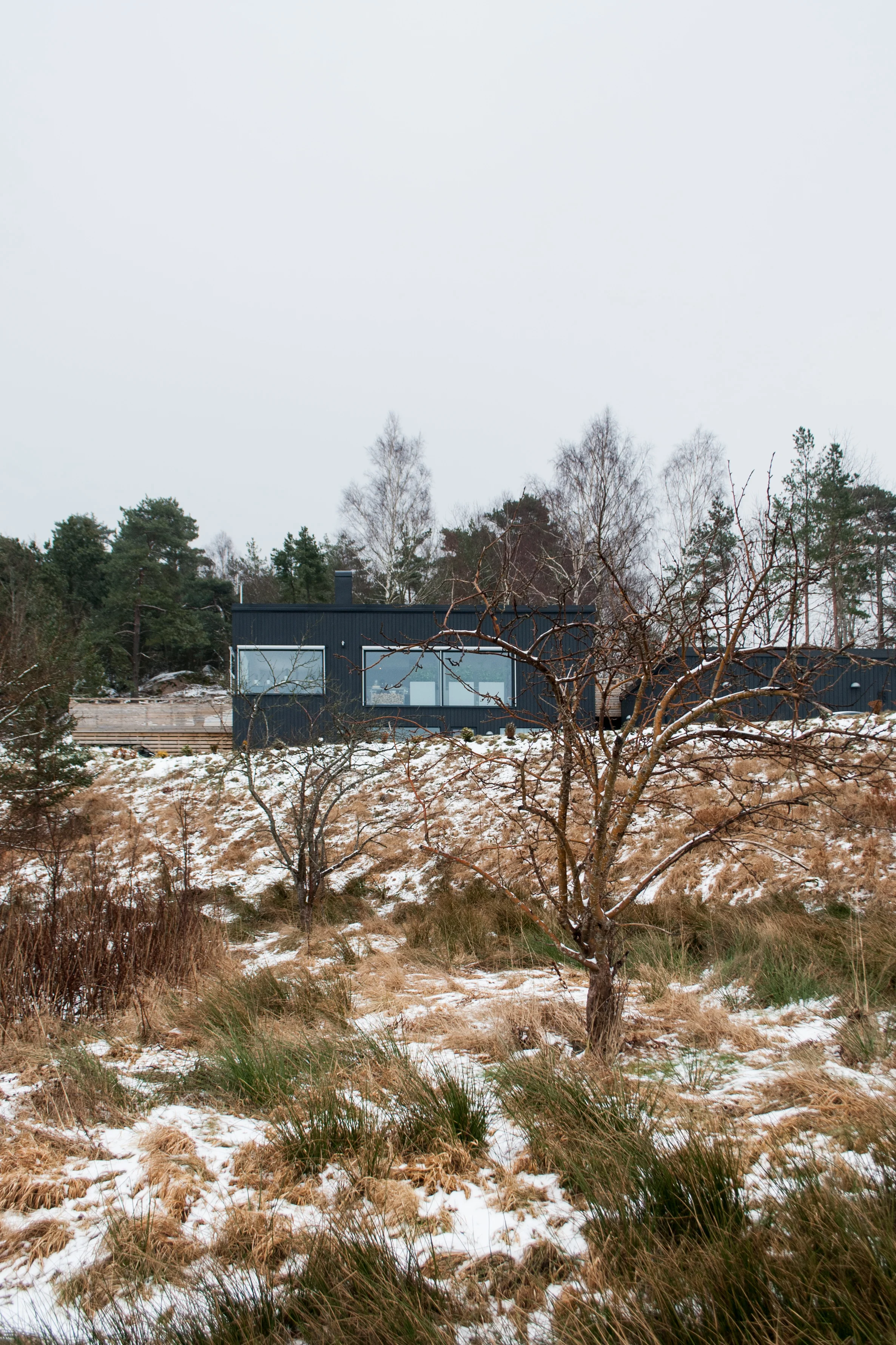  Situated on the outskirts of Gothenburg, this villa clings to a steep slope, incorporating the terrain within its layout. While at the front appearing large, clearly announcing itself from far away, the backside is low, private and cosy. 