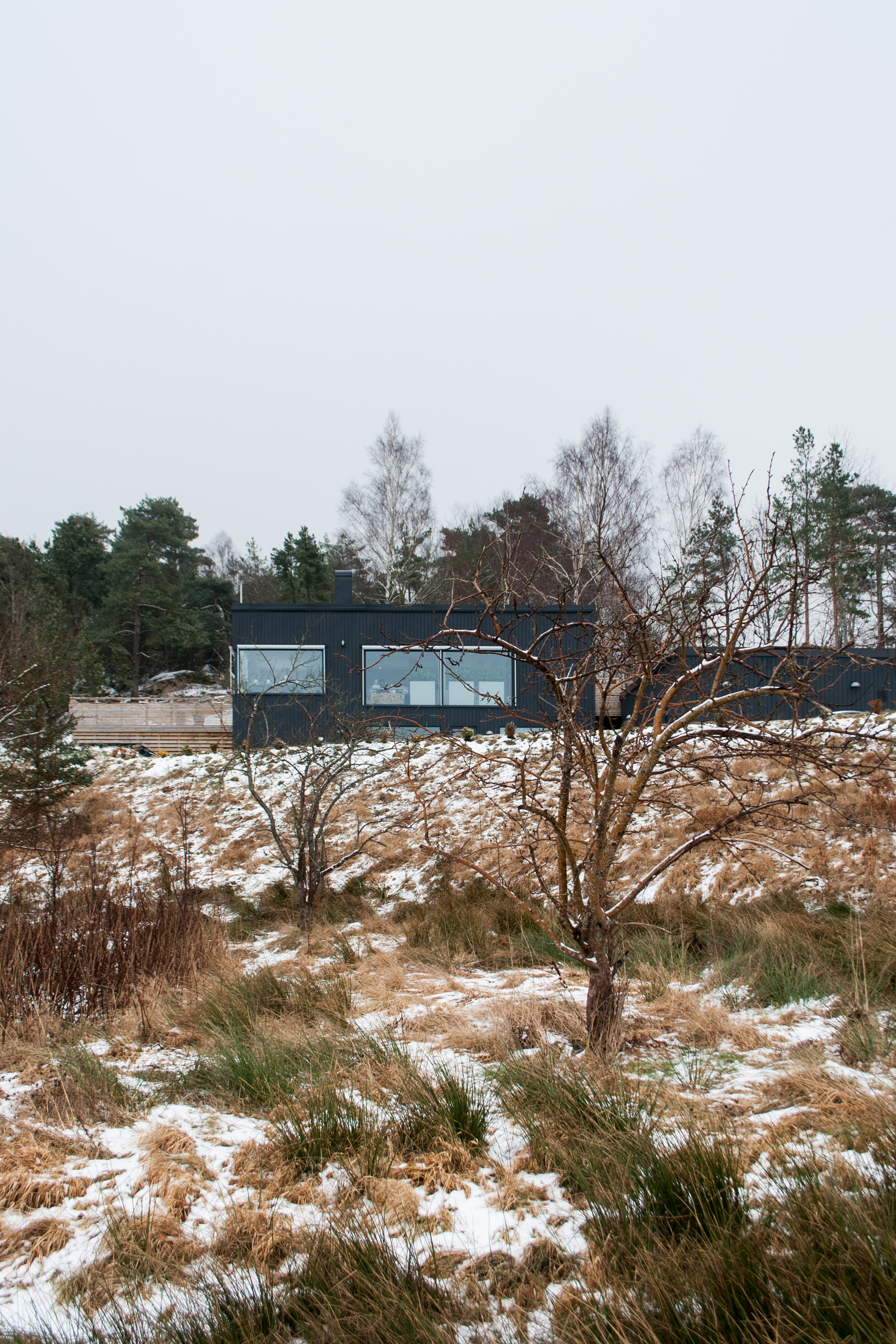  Situated on the outskirts of Gothenburg, this villa clings to a steep slope, incorporating the terrain within its layout. While at the front appearing large, clearly announcing itself from far away, the backside is low, private and cosy. 