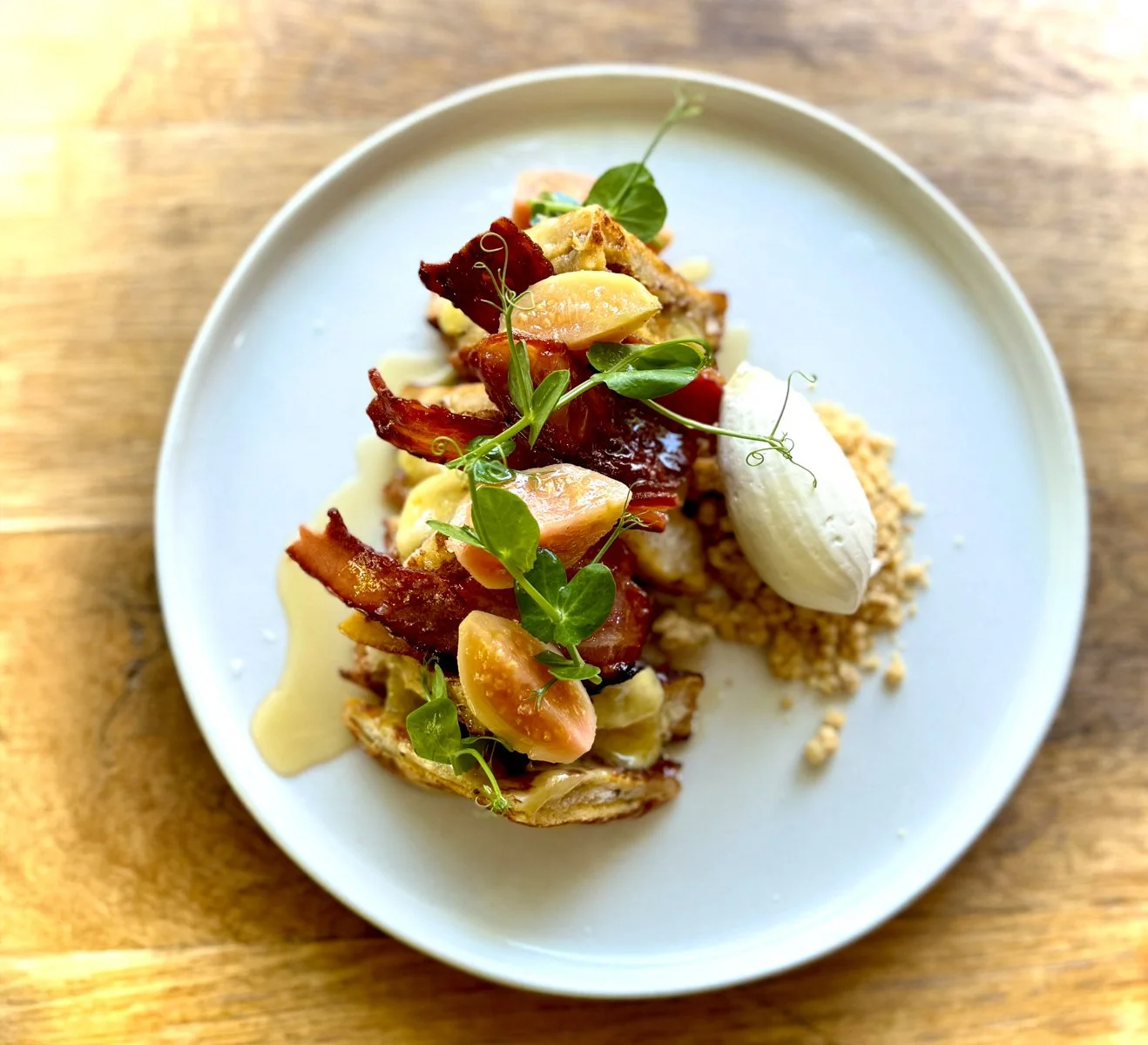 Indulge in our Milk Bread French Toast &ndash; a perfect balance of sweet and savoury. Served with compressed seasonal fruit, smoky bacon, matured cheddar, and lemon thyme streusel, finished with whipped sour cream &amp; honey. Make it even more sati