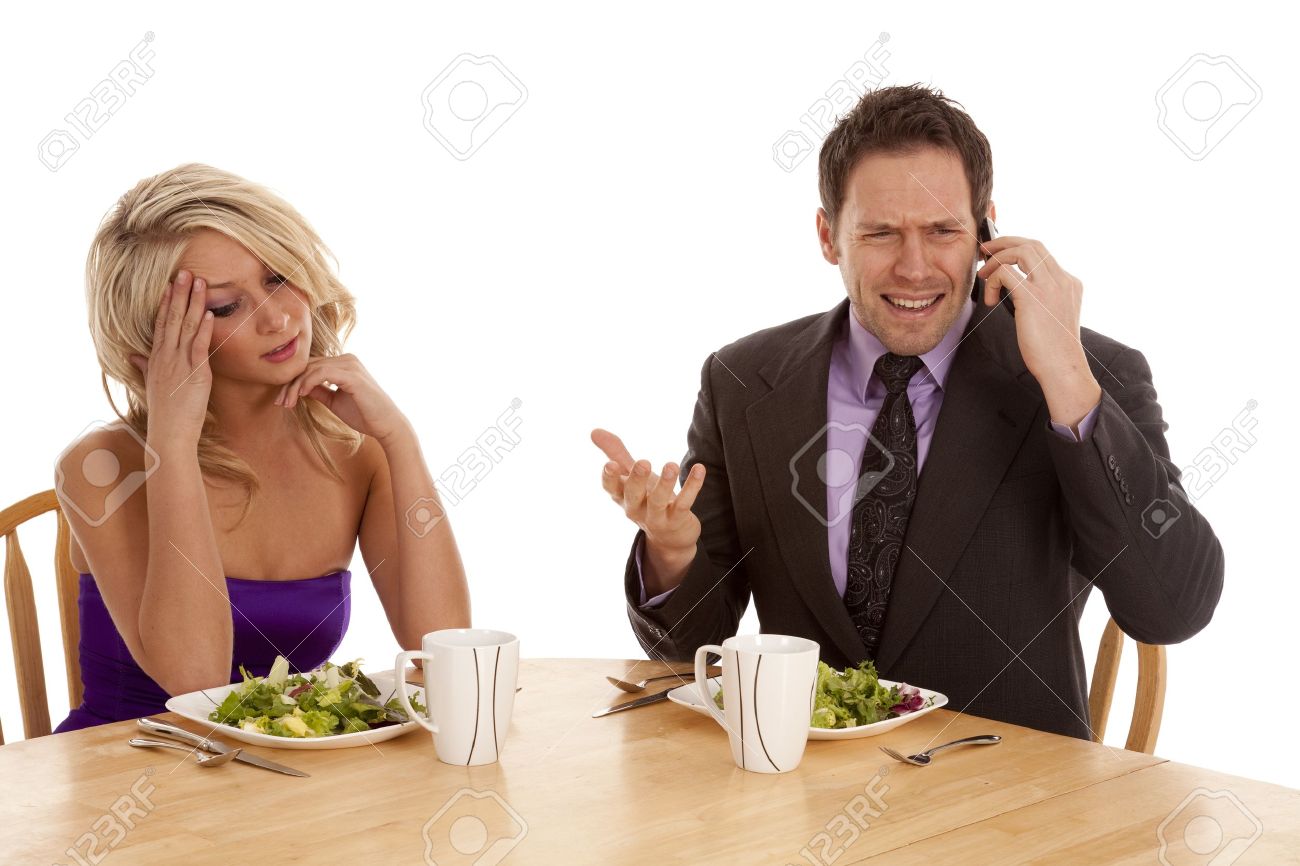9321067-a-woman-sitting-and-being-frustrated-with-her-man-because-he-is-on-the-phone-while-they-are-having-a-Stock-Photo.jpg