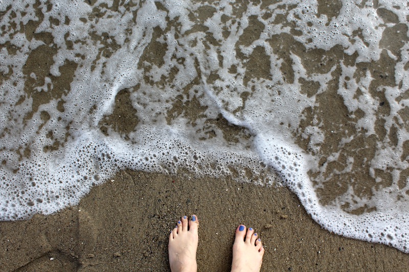 Toes in the dark sand of Santa Monica.