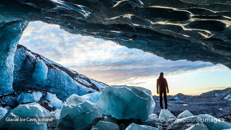 Man Standing in Ice Cave Entrance