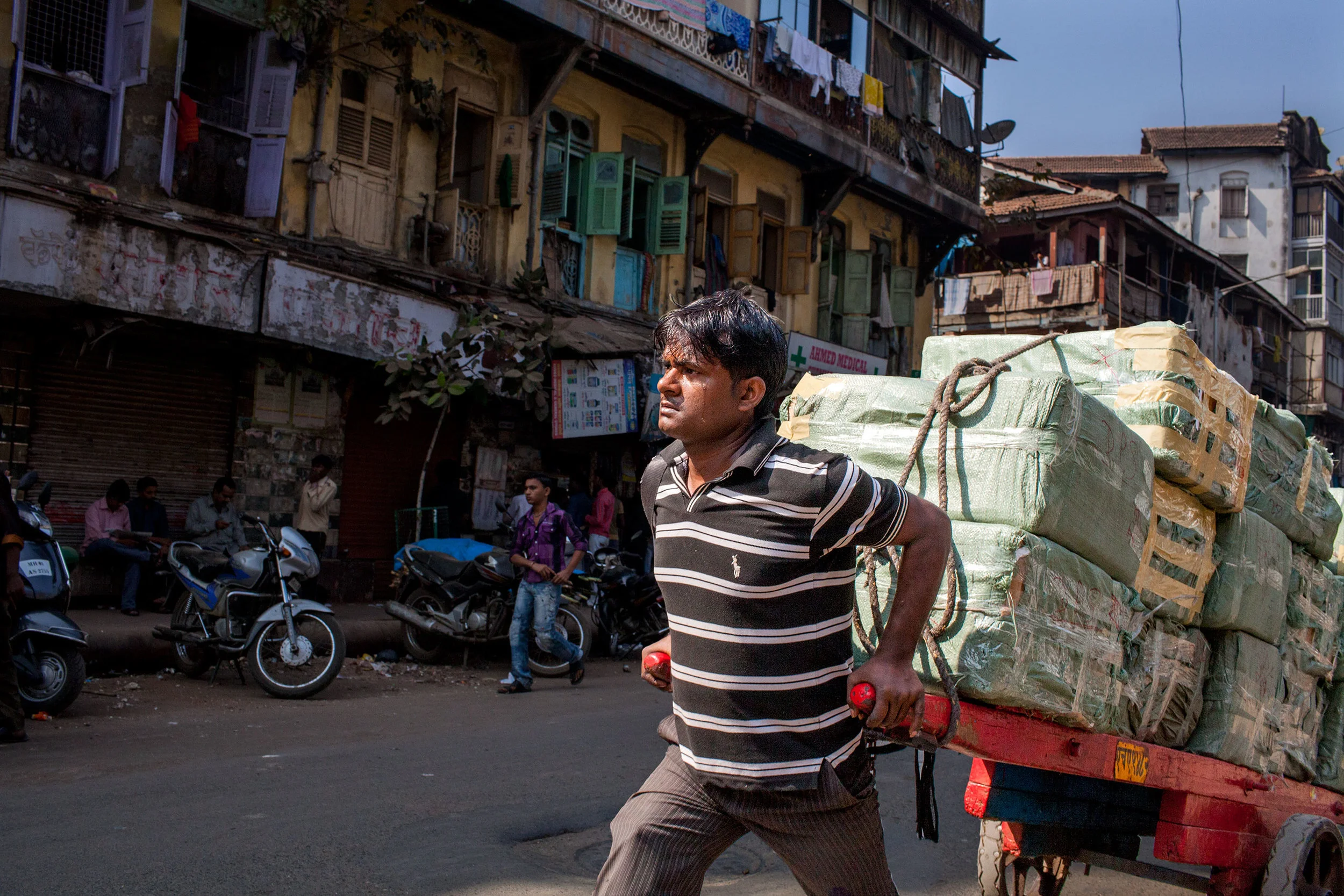 Dunk-McKenzie-PublicDomain-porter-cart-puller-man-pulling-loaded-cart-bendhi-bazaar-mumbai-india.jpg
