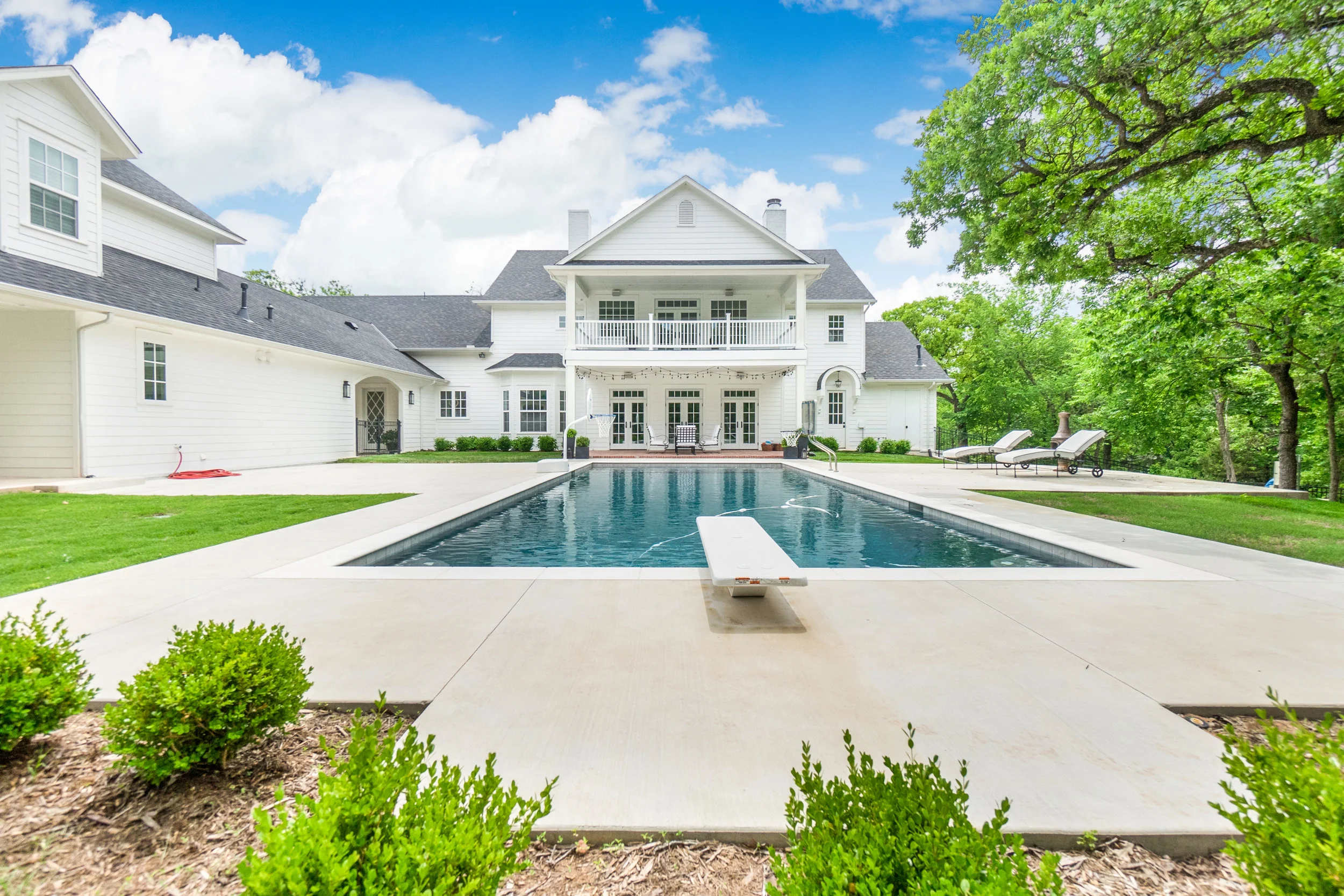 From the back. You'll note the carriage house/cabana on the left. The lot rolls down to a well-landscaped creek area. Zipline is tucked away on the side of the house.