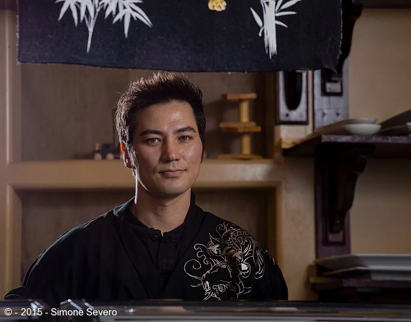 Sam is an artist. Heis a sushi chef. He creates beautiful food that you almost feel sorry to eat. He likes motorcycles and he does not like winter. Yet, he lives in Colorado. He&nbsp;agreed to have is portrait taken with no notice: I invited him whi…