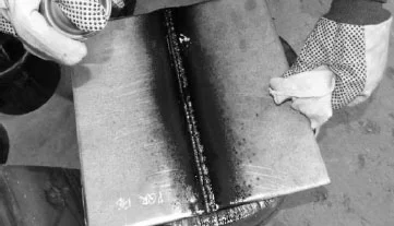Liquid Penetrant Testing. Developer application using aerosol spray can.