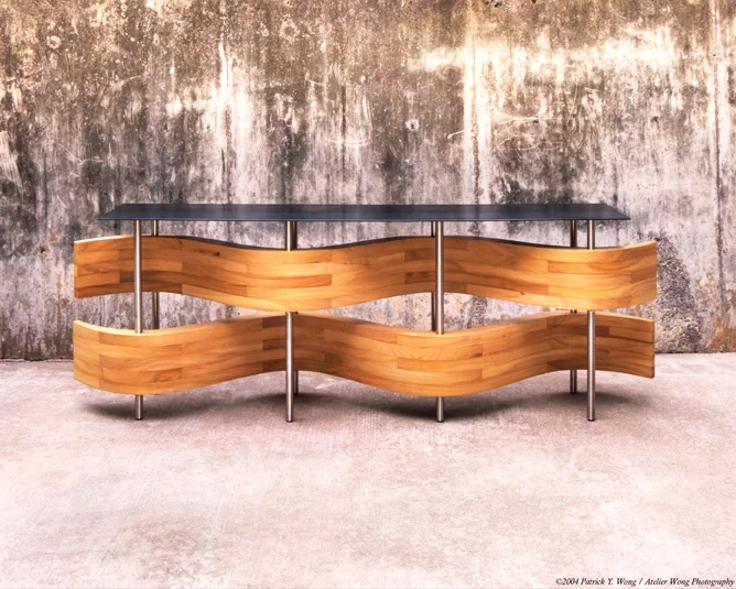 Snyder Donahue Entry Table, design in collaboration with Miro Rivera Architects, 2004 The "ribbons" were stack-laminated cypress, chosen to compliment the cypress millwork in the house. The steel top and stainless steel legs were made by Hawkeye Glenn. 9'-0" l x 1'-8" d x 32" h Photo by Patrick WOng