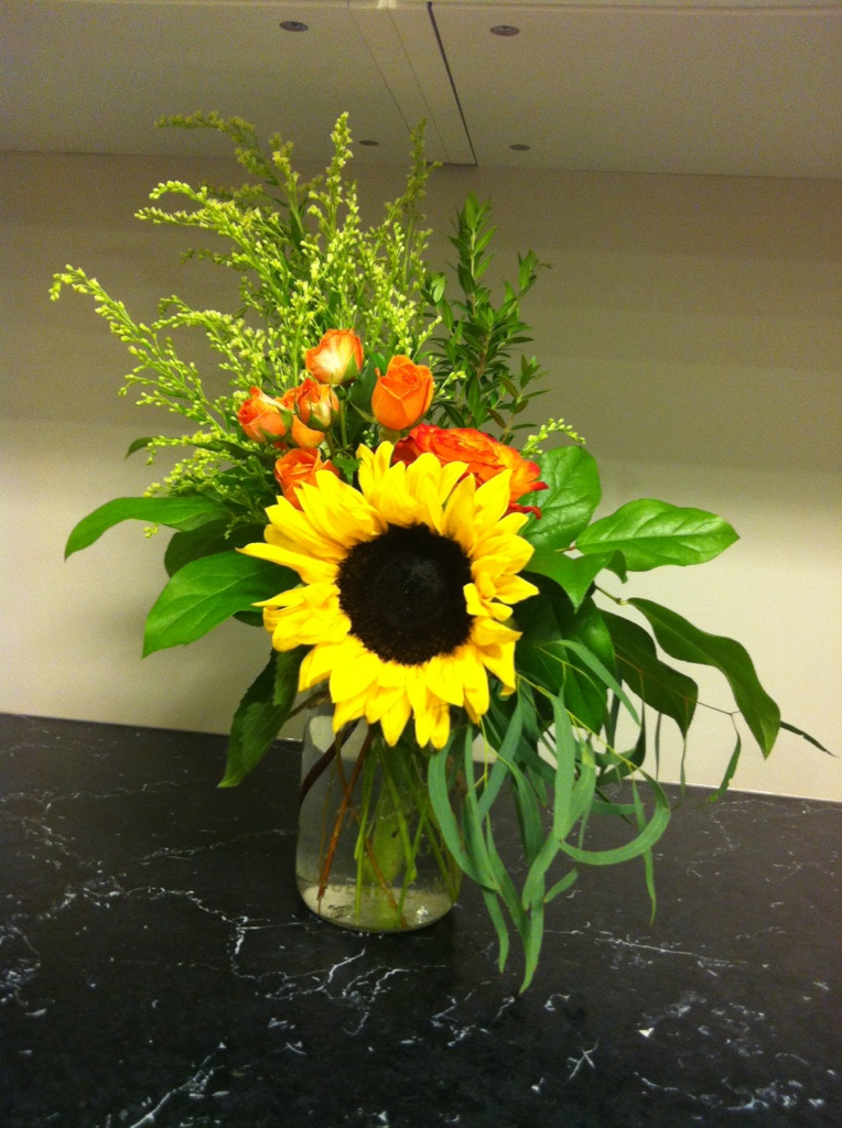 Sunflowers and orange roses in a mason jar 