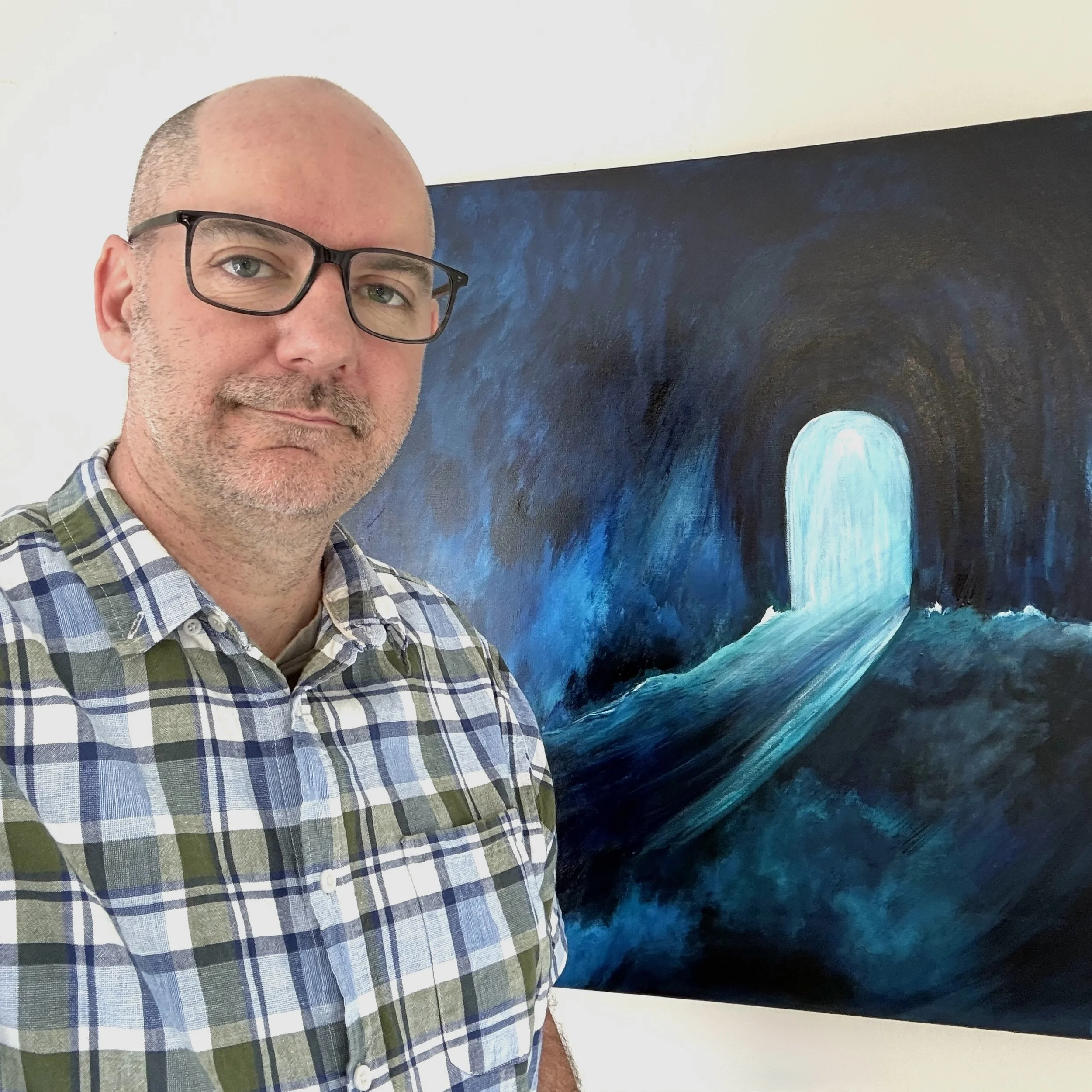 Scott Morgan, counsellor and MBTI practitioner, standing beside one of his original paintings.