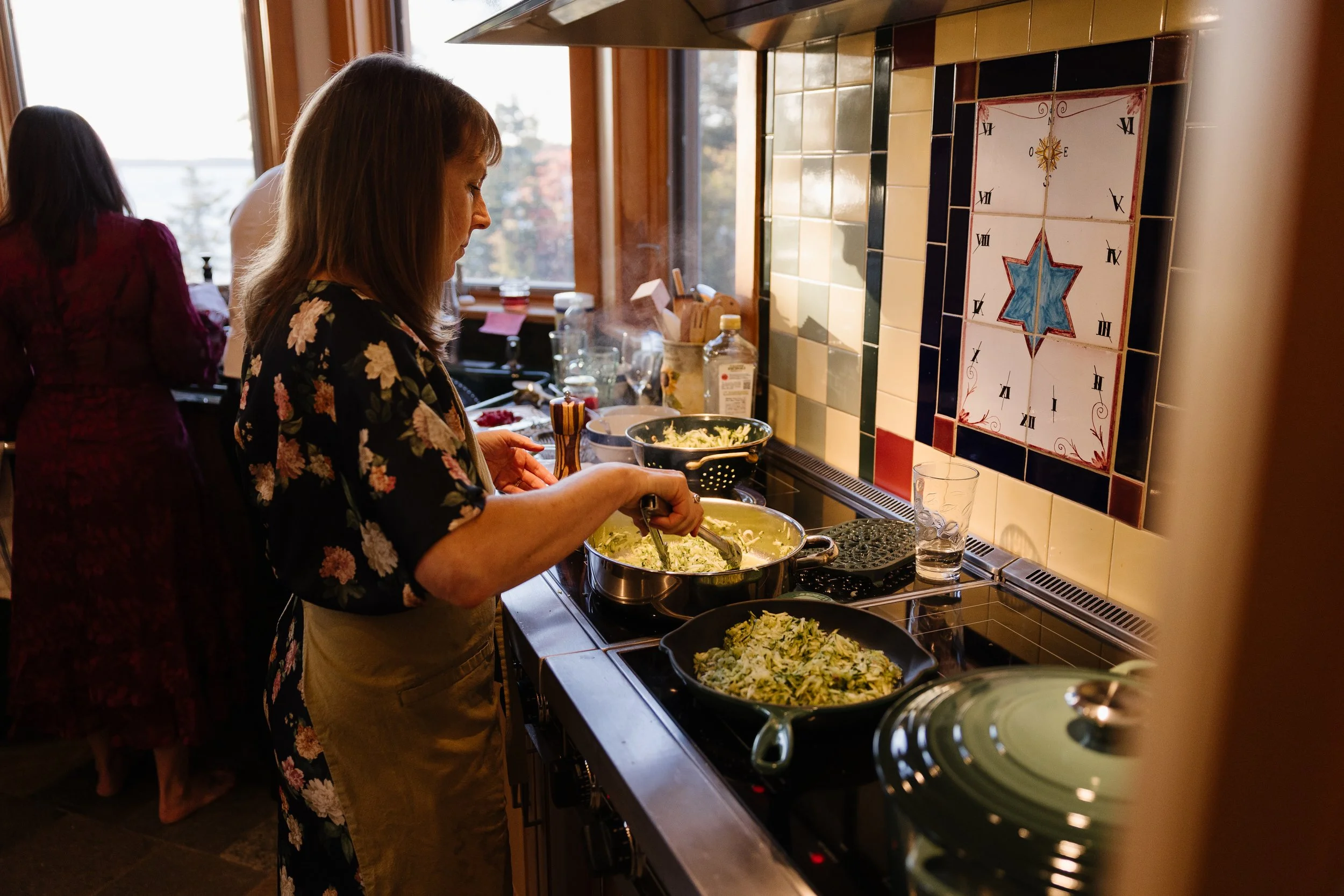 Family cooks during a non-traditional wedding at a rental in Maine. Photography by Sienna Renee Photography.