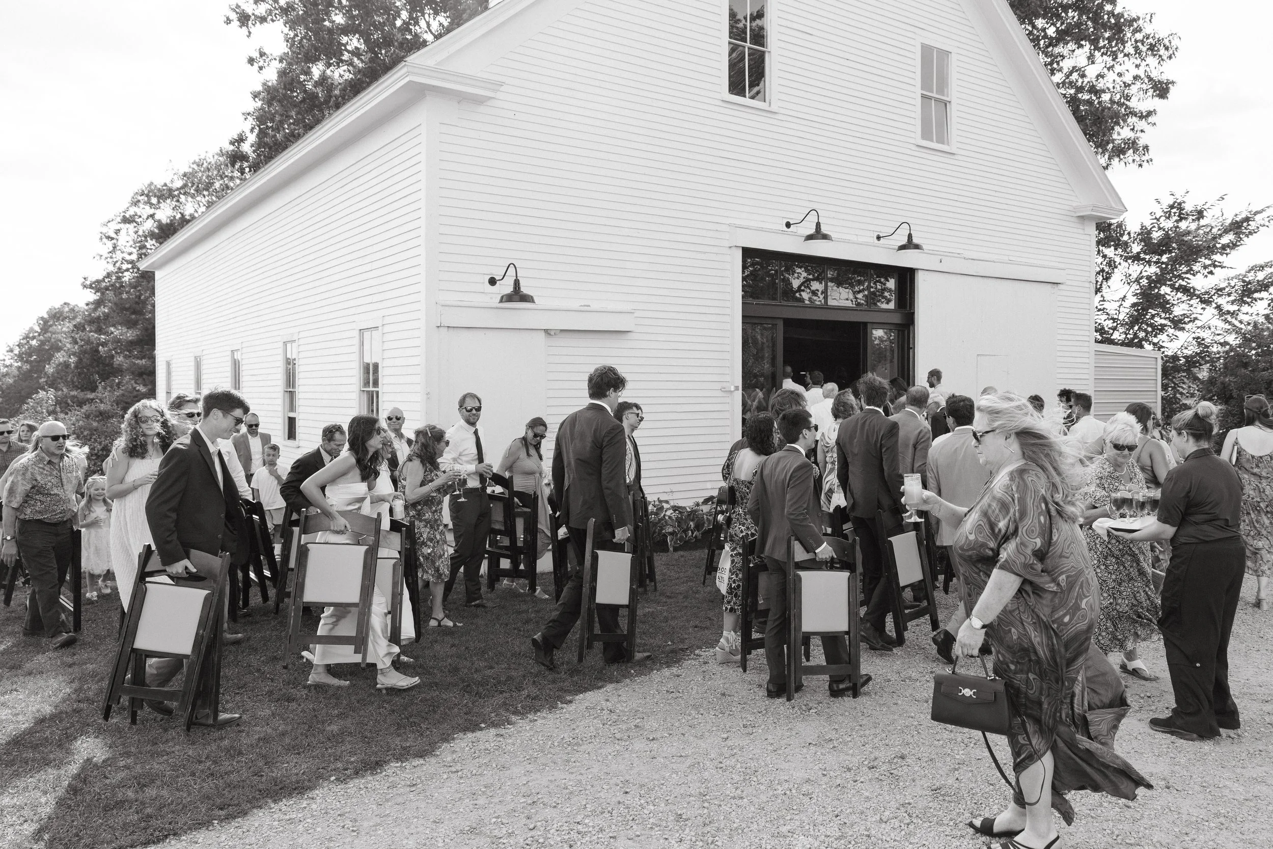 A couple takes each other's hands as they walk down from walks during their intimate wedding day at Aragosta in Deer Isle, Maine. Photography by Sienna Renee Photography.