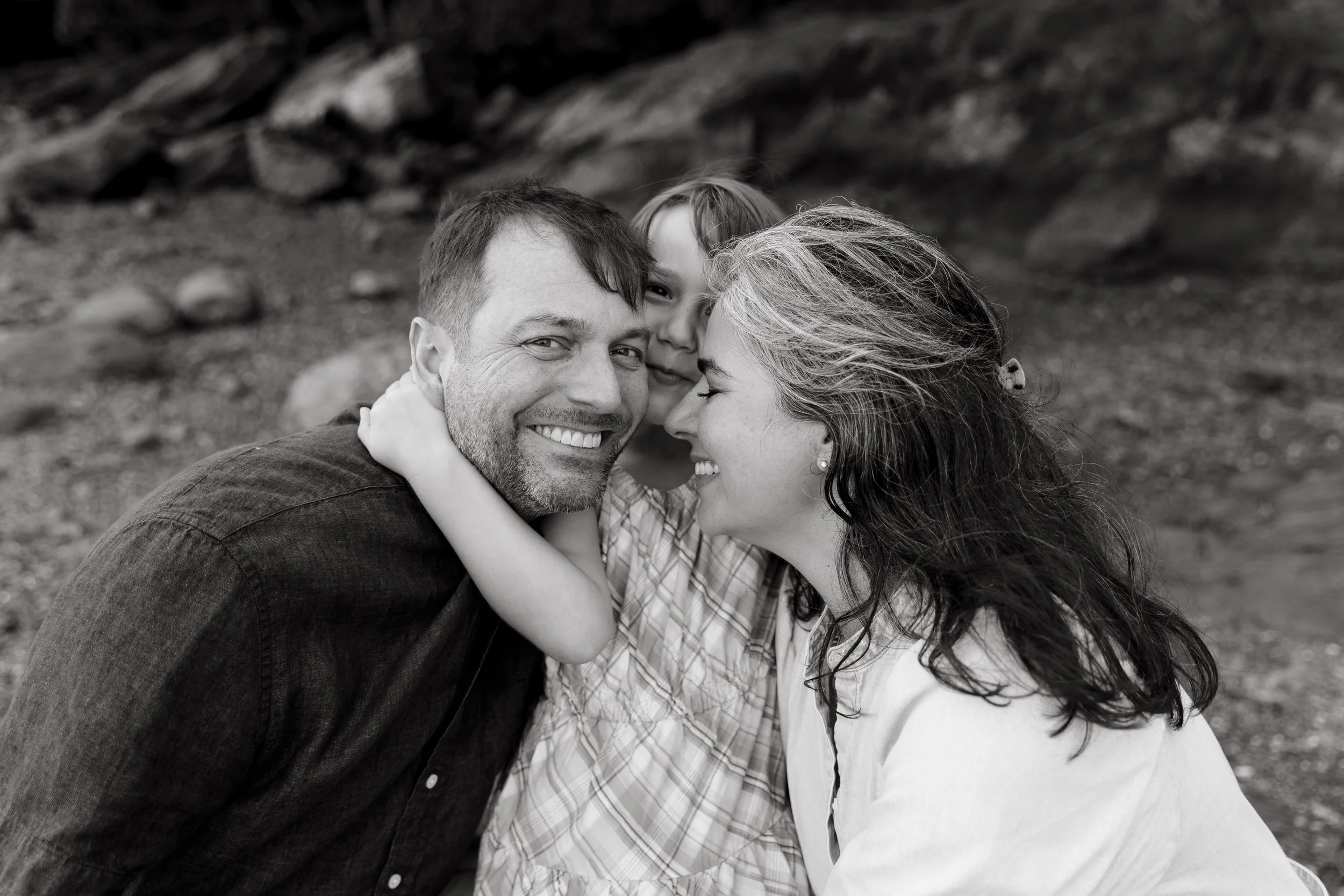 A family smiles and gets close during their visit to Maine. Photography by Sienna Renee Photography.