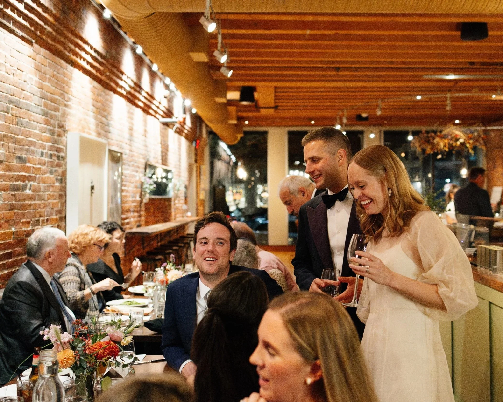 A couple mingles during their wedding dinner at Solo Italiano in Portland, Maine. Photography by Sienna Renee Photography.