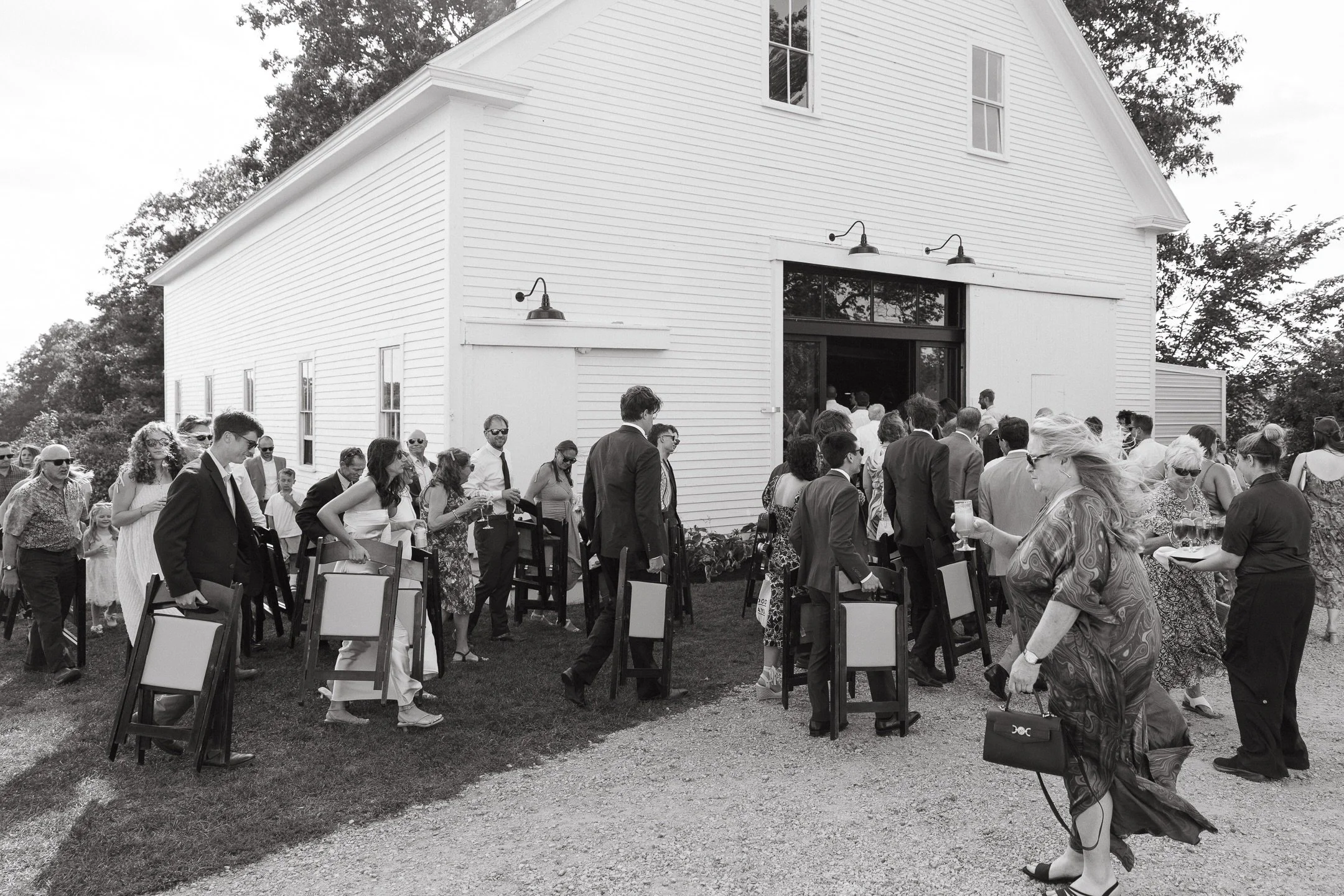 Photographed during Colby &amp; Zach&rsquo;s day &mdash; friends and family carrying chairs to the barn, chatting with drinks in hand.

Maine wedding photographer
Scotland Fields wedding
Maine documentary wedding photographer