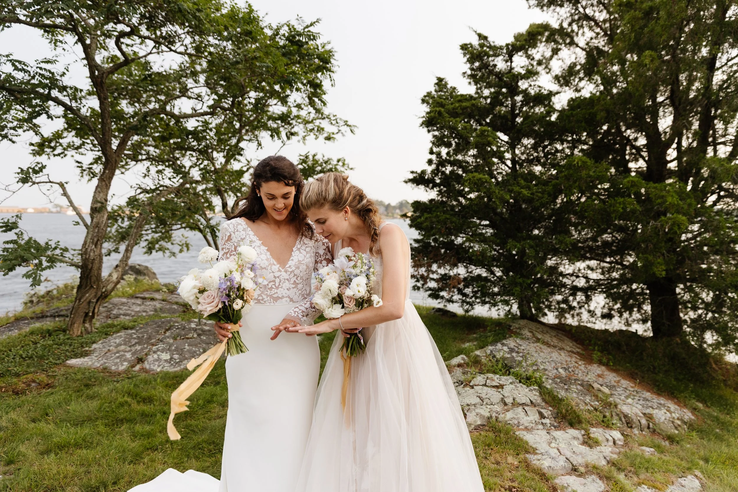 A couple looks at their rings after they just got married on the coast of Maine. Photography by Sienna Renee Photography.