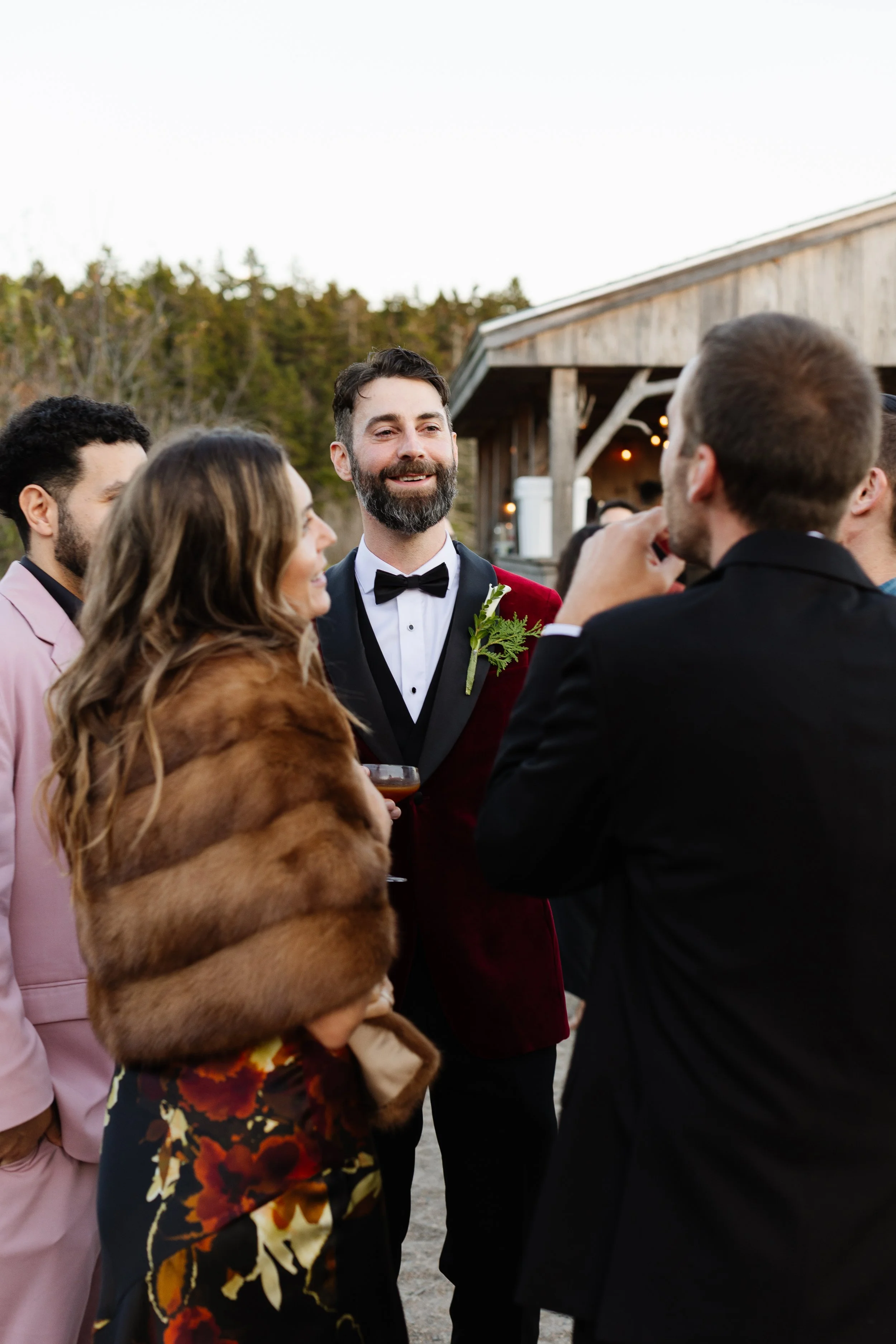A groom and his friends laugh together during an intimate wedding weekend at Aragosta at Goose Cove in Deer Isle, Maine. Photography by Sienna Renee Photography.