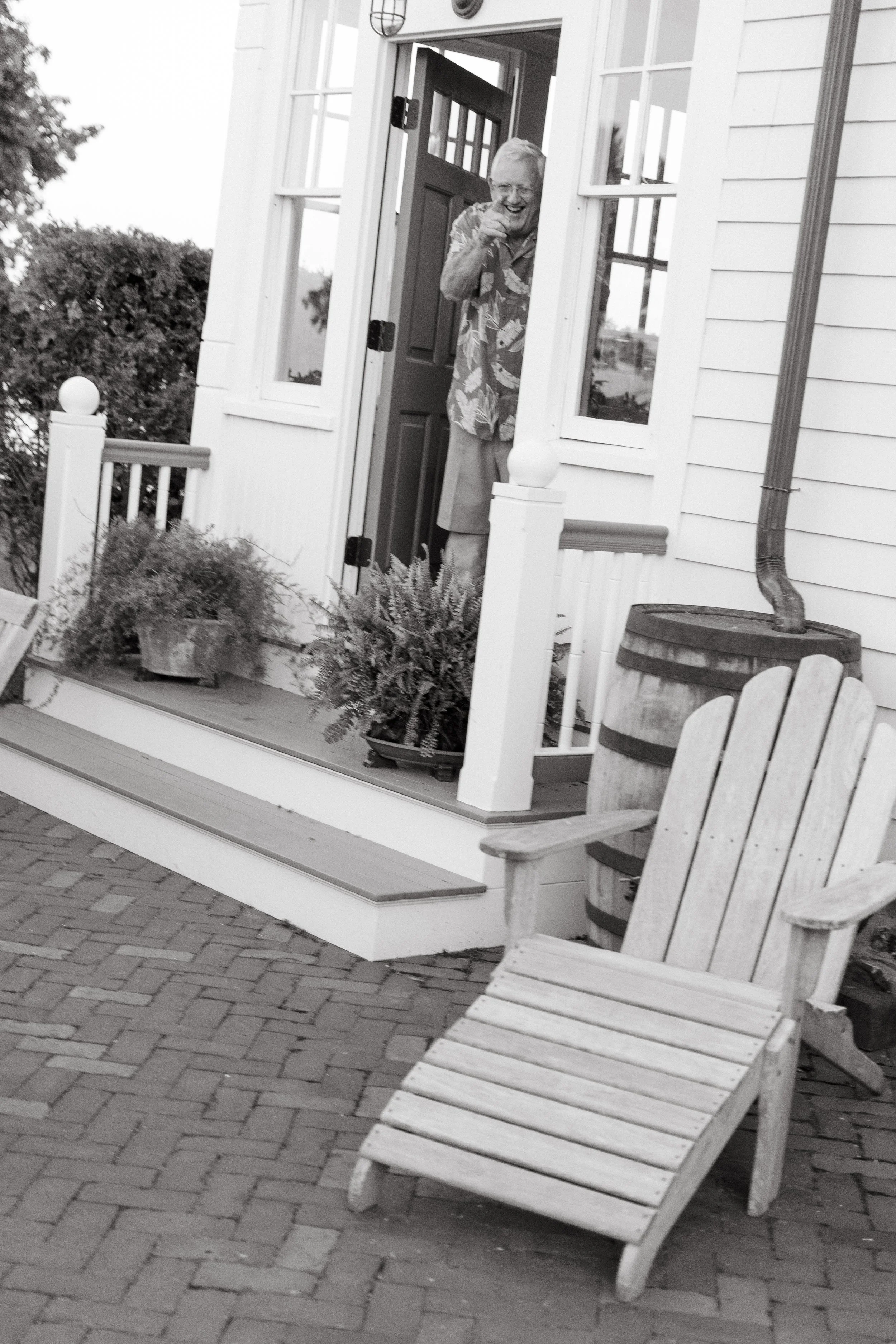 A family member points to the camera and smiles during a small backyard wedding. Photography by Sienna Renee Photography.
