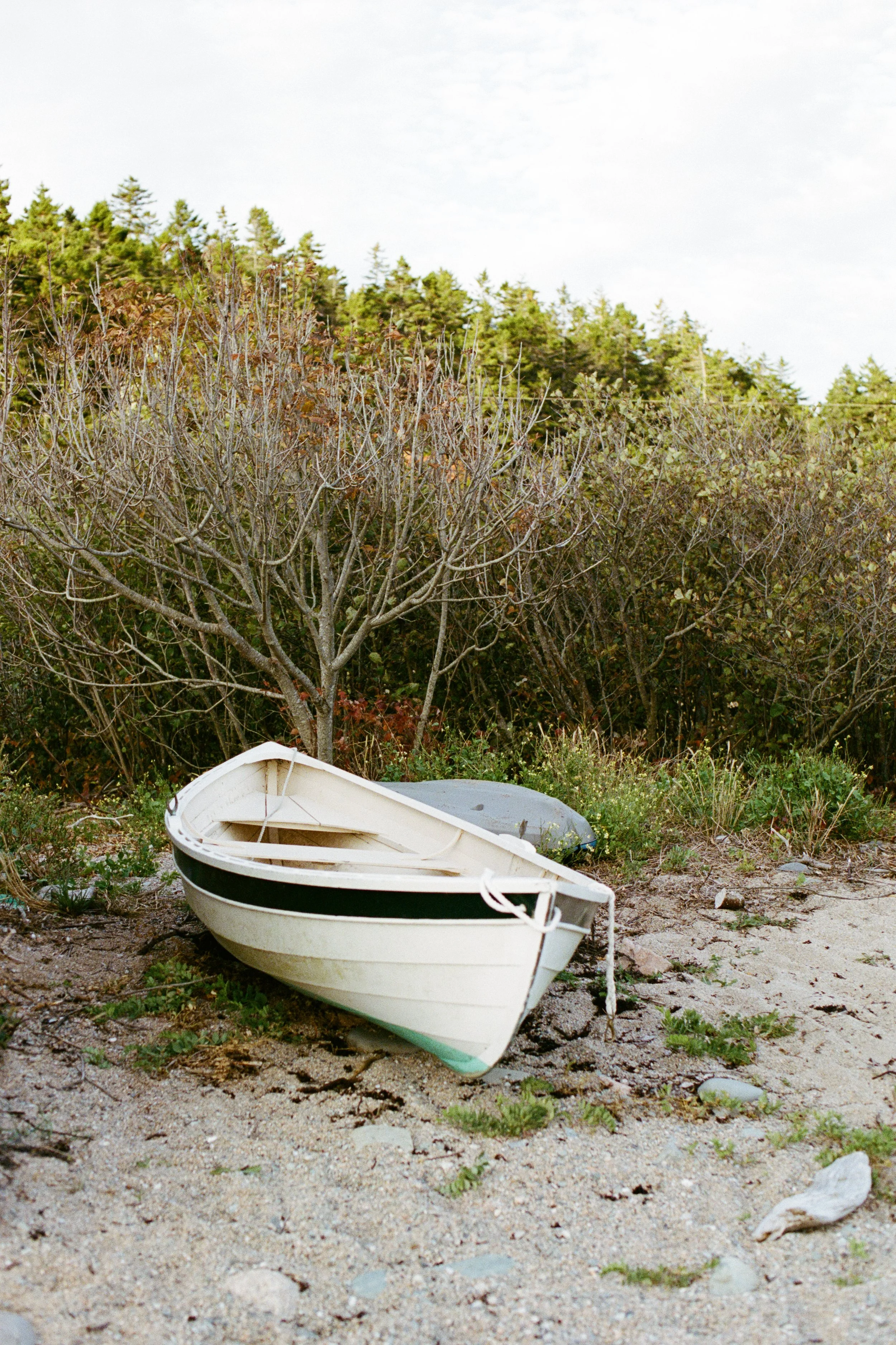 A boat on the beach during an intimate wedding weekend at Aragosta in Deer Isle, Maine. Photography by Sienna Renee Photography.